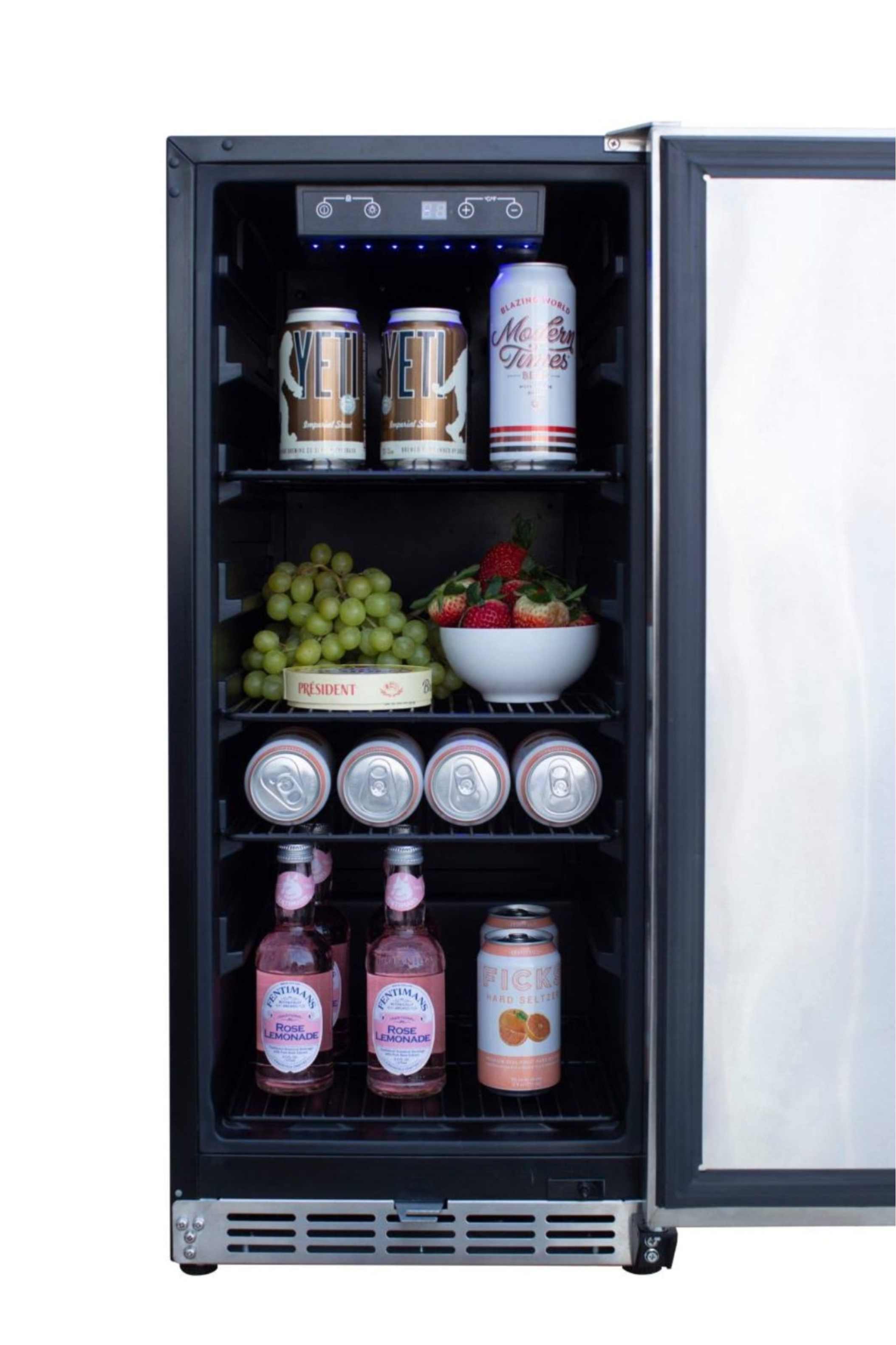 Outdoor refrigerator with open door, wire shelves stocked with drinks and fruit