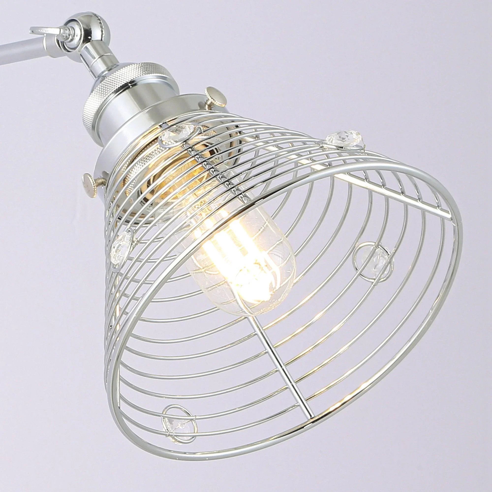 Close-up silver wall sconce showing wire cage shade and exposed bulb inside
