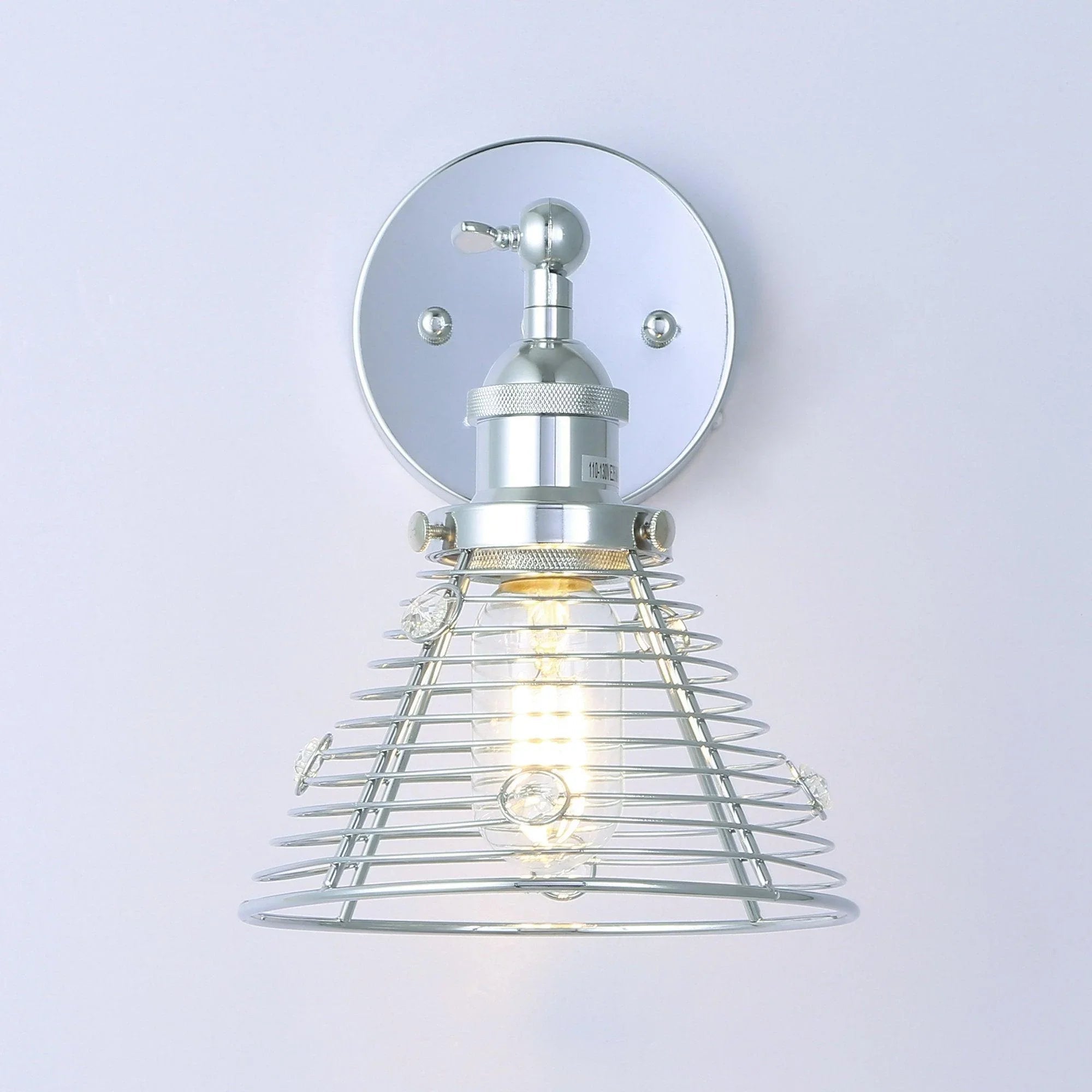 Silver wall sconce with round plate mount and curved metal wire cage with exposed bulb