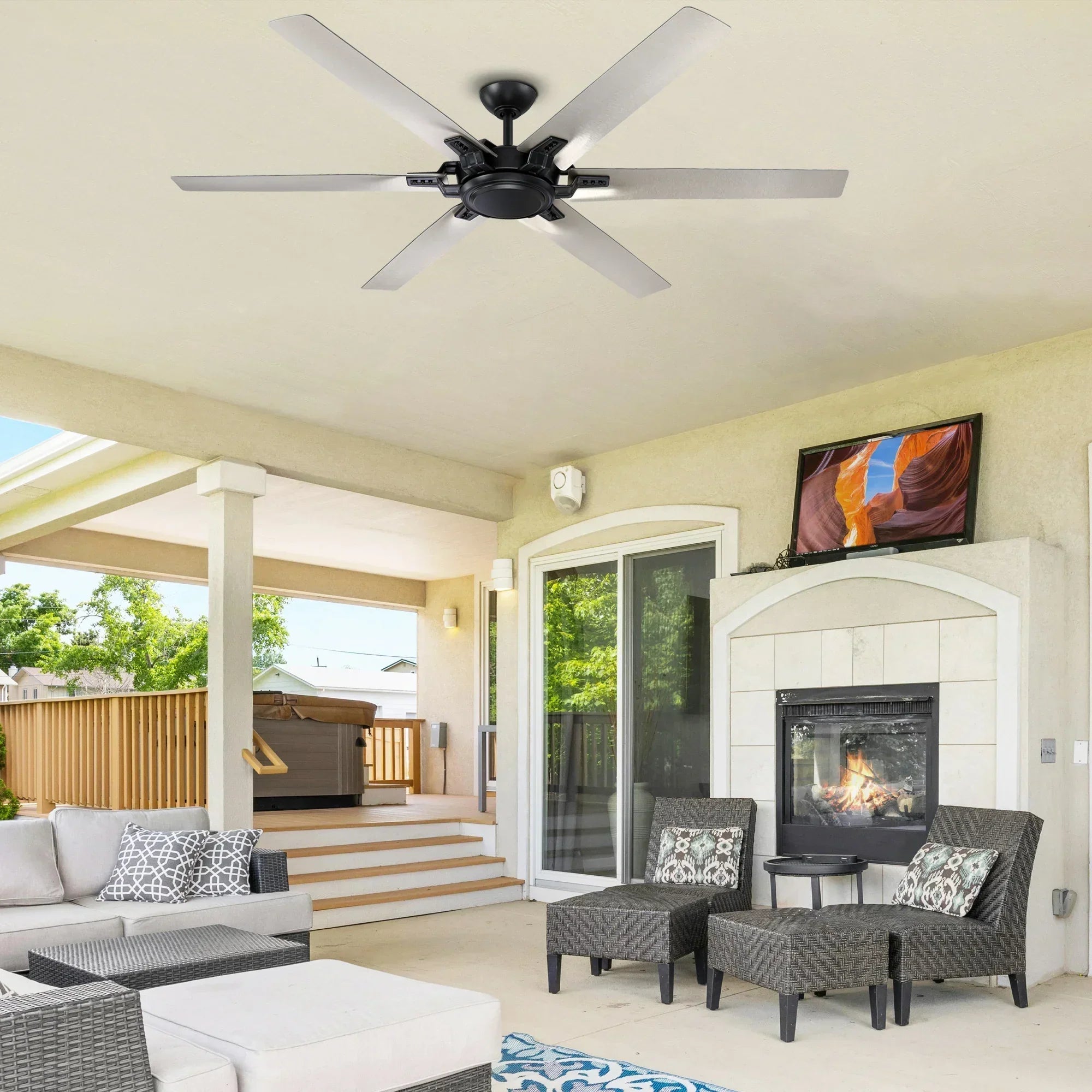 Black industrial ceiling fan with 5 blades on covered outdoor patio ceiling.