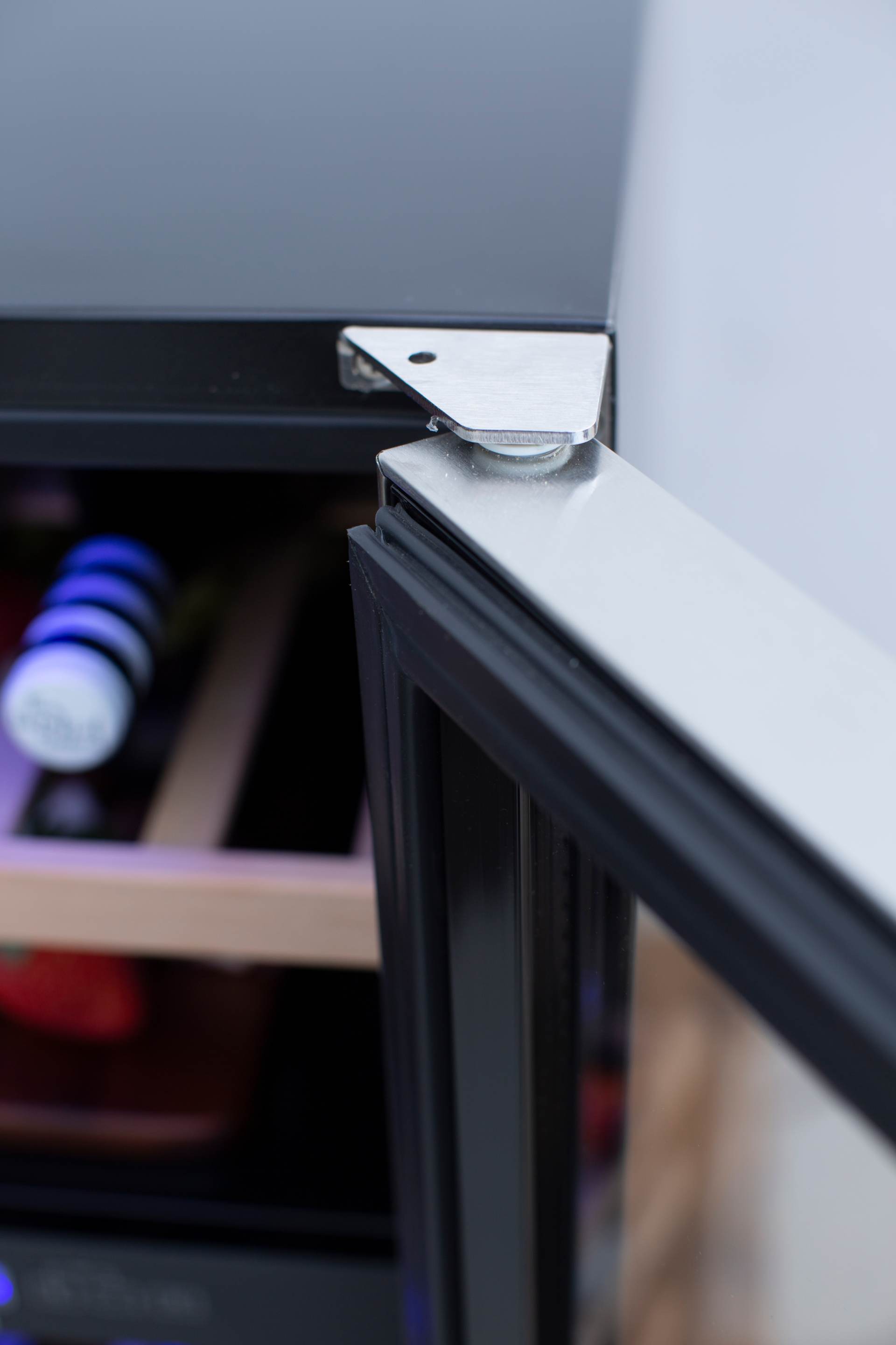 Wine cooler door hinge and mounting bracket detail in stainless metal