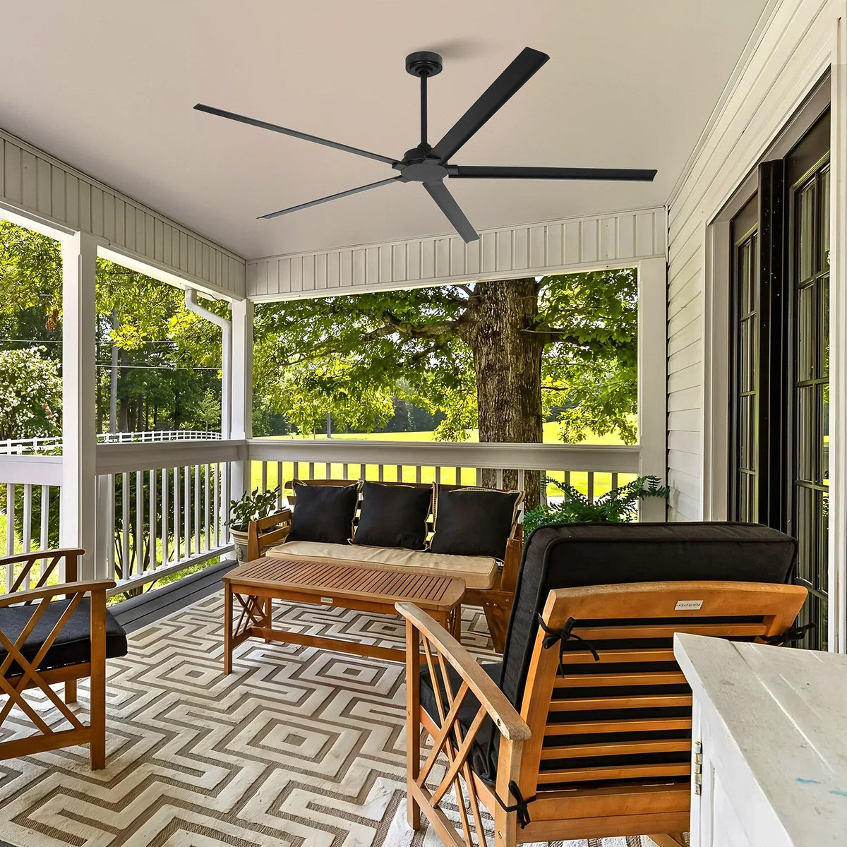 Black outdoor ceiling fan with five blades on a covered porch ceiling