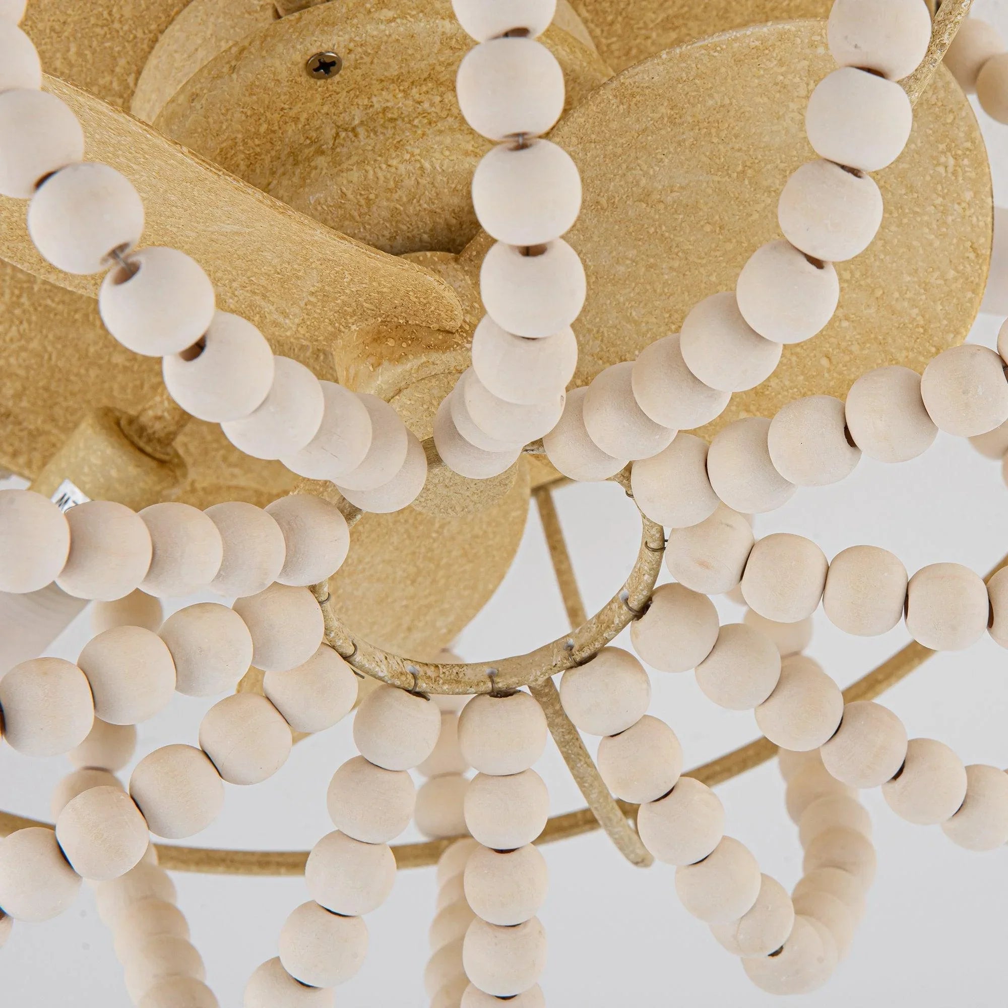 Beige flush mount ceiling fan center hub with white bead strands and gold frame