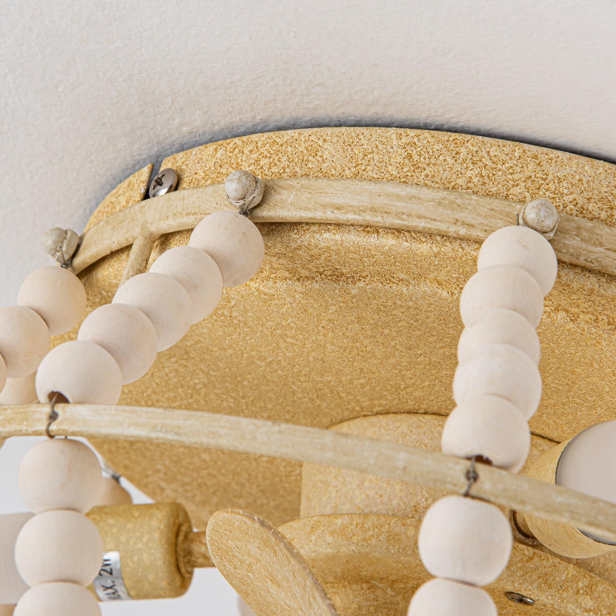 Beige ceiling fan mount with white bead trim and metal bracket near the canopy