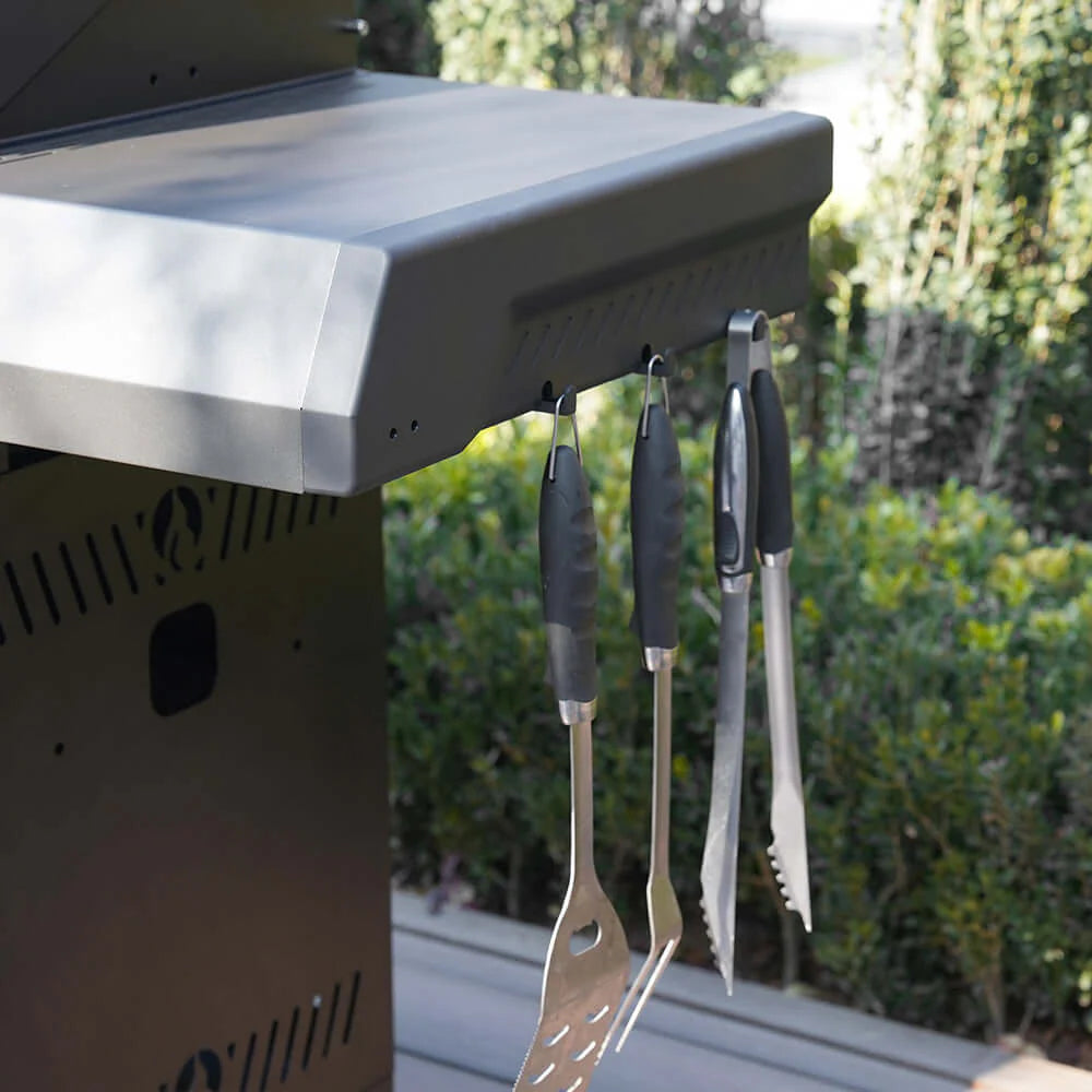 Black grill side area with utensils hanging from the right side panel