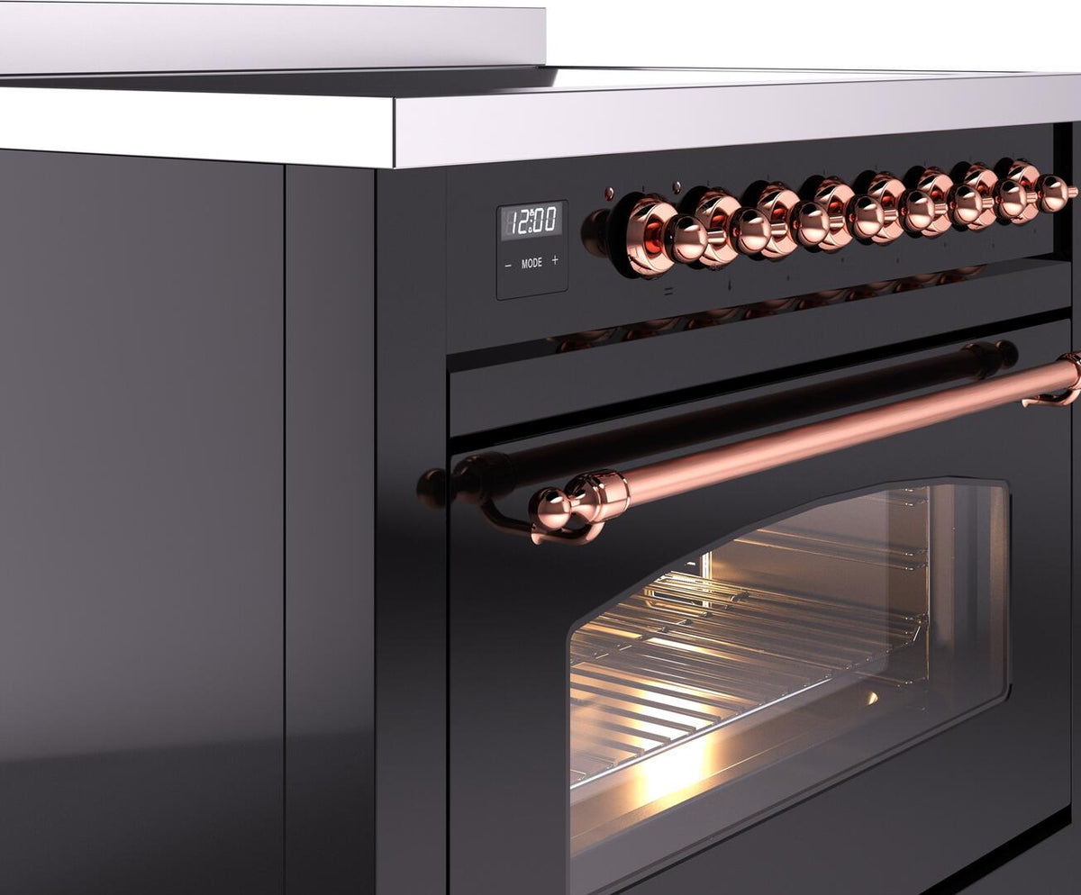 Freestanding induction range close-up of copper control knobs and oven handle.