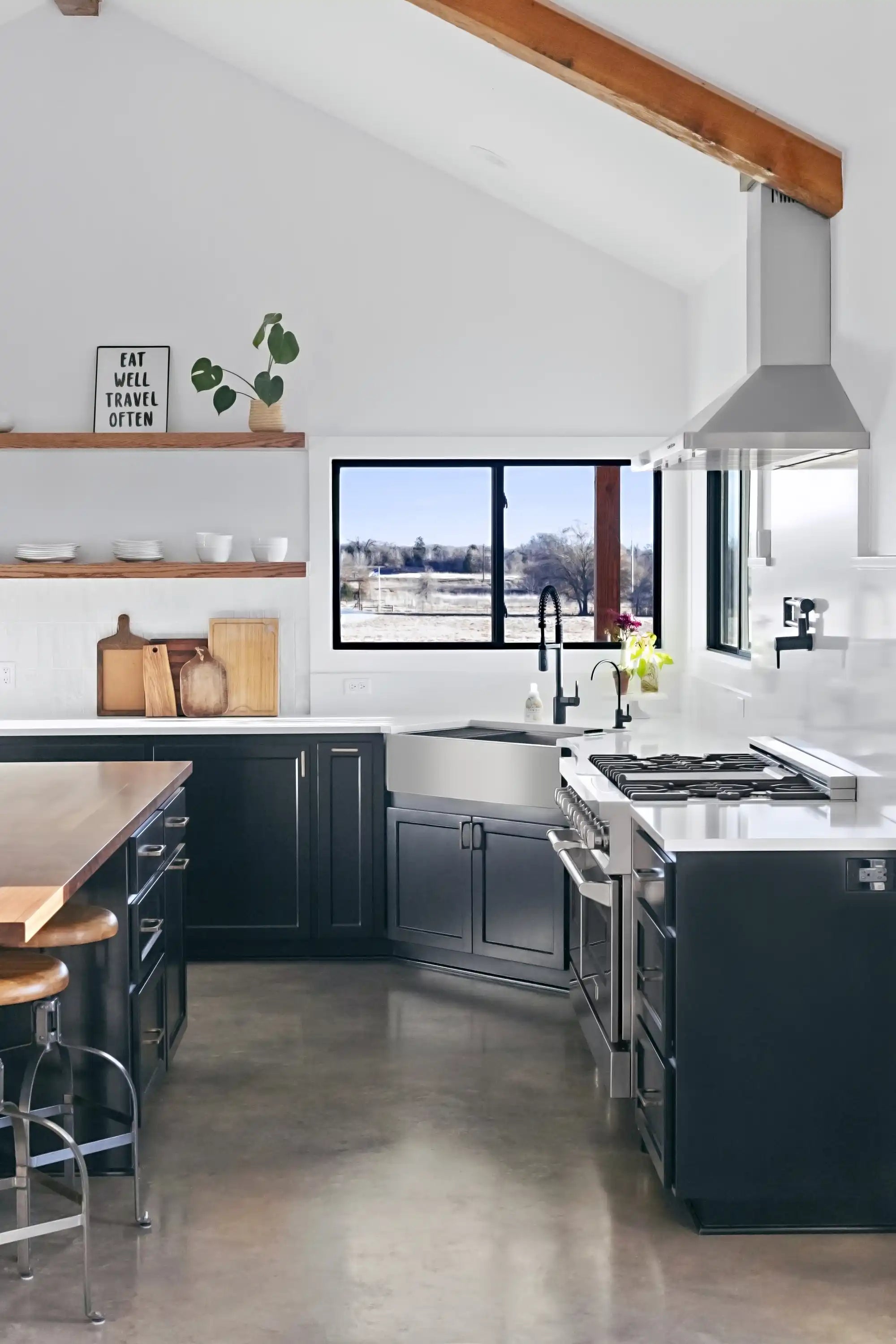Stainless steel range hood over a kitchen cooktop with minimalist cabinetry