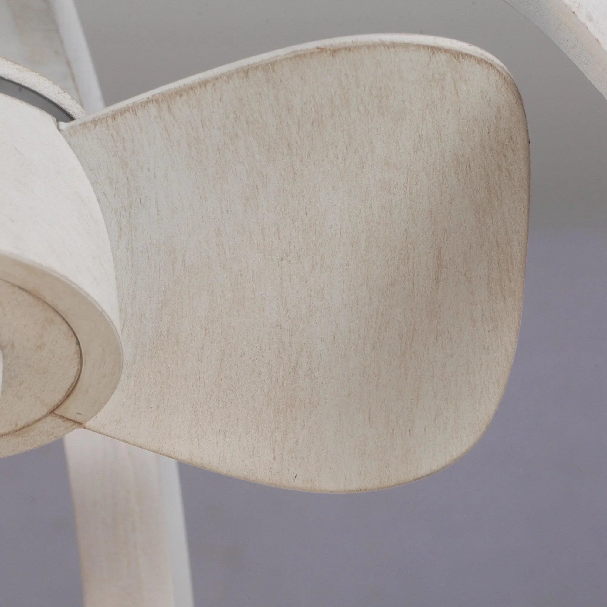 Textured white ceiling fan blade with smooth mounting hub, close-up