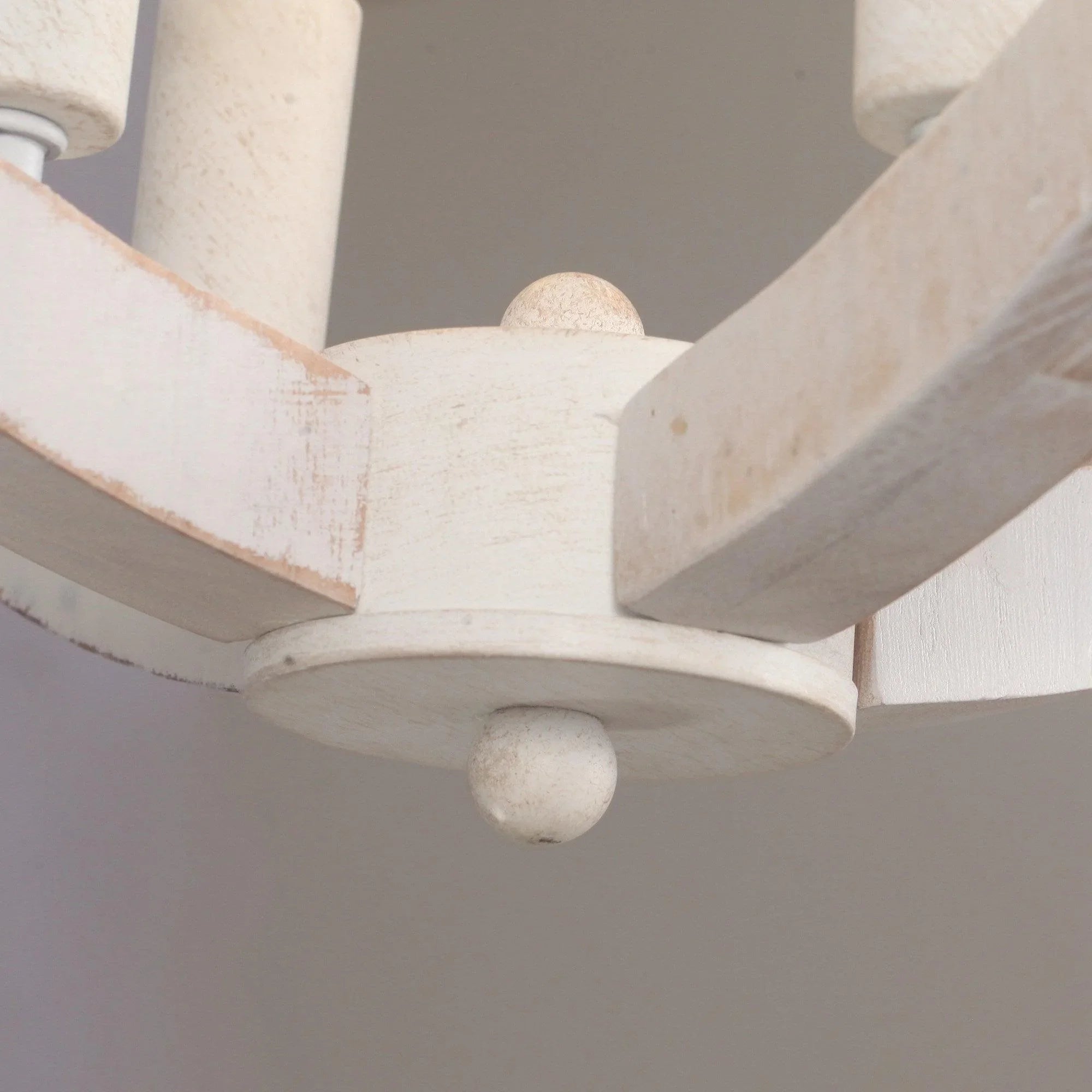 Ceiling fan motor housing and blade root in textured white, close-up