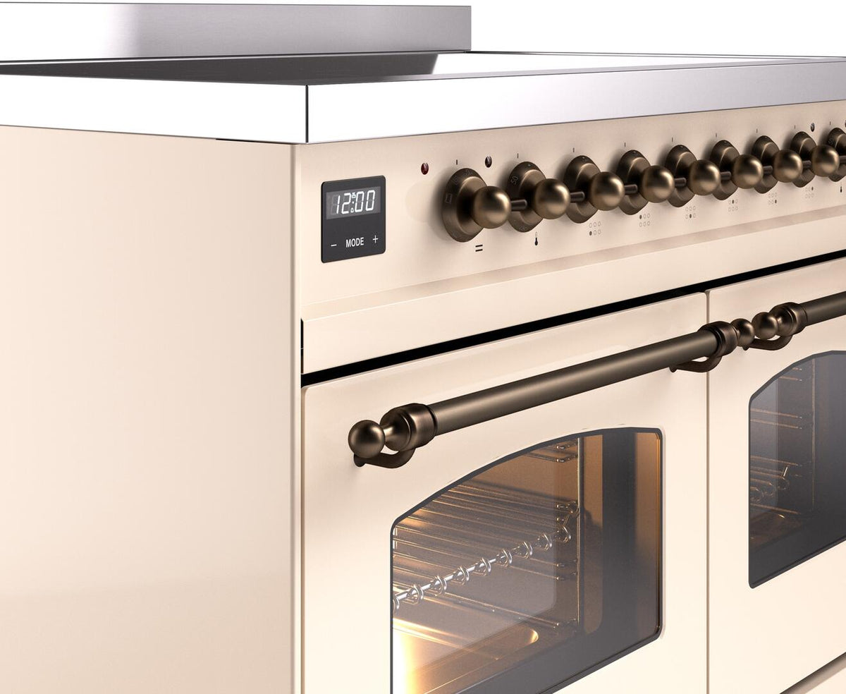 Antique white induction range control panel with bronze knobs and oven handle detail
