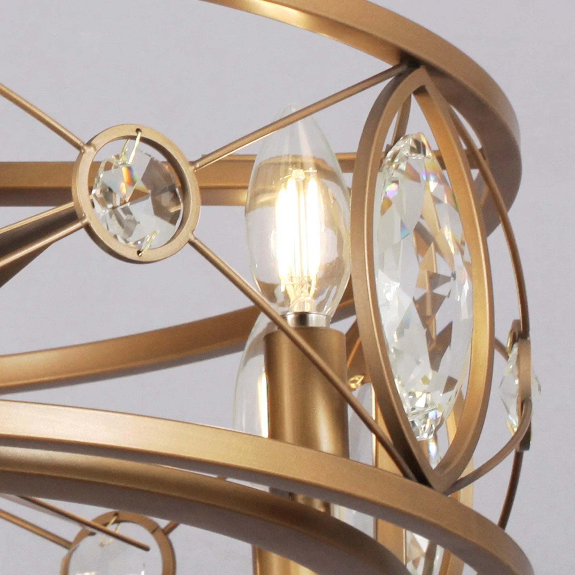 Gold ceiling fan chandelier close-up of crystal ovals and glowing candle bulbs
