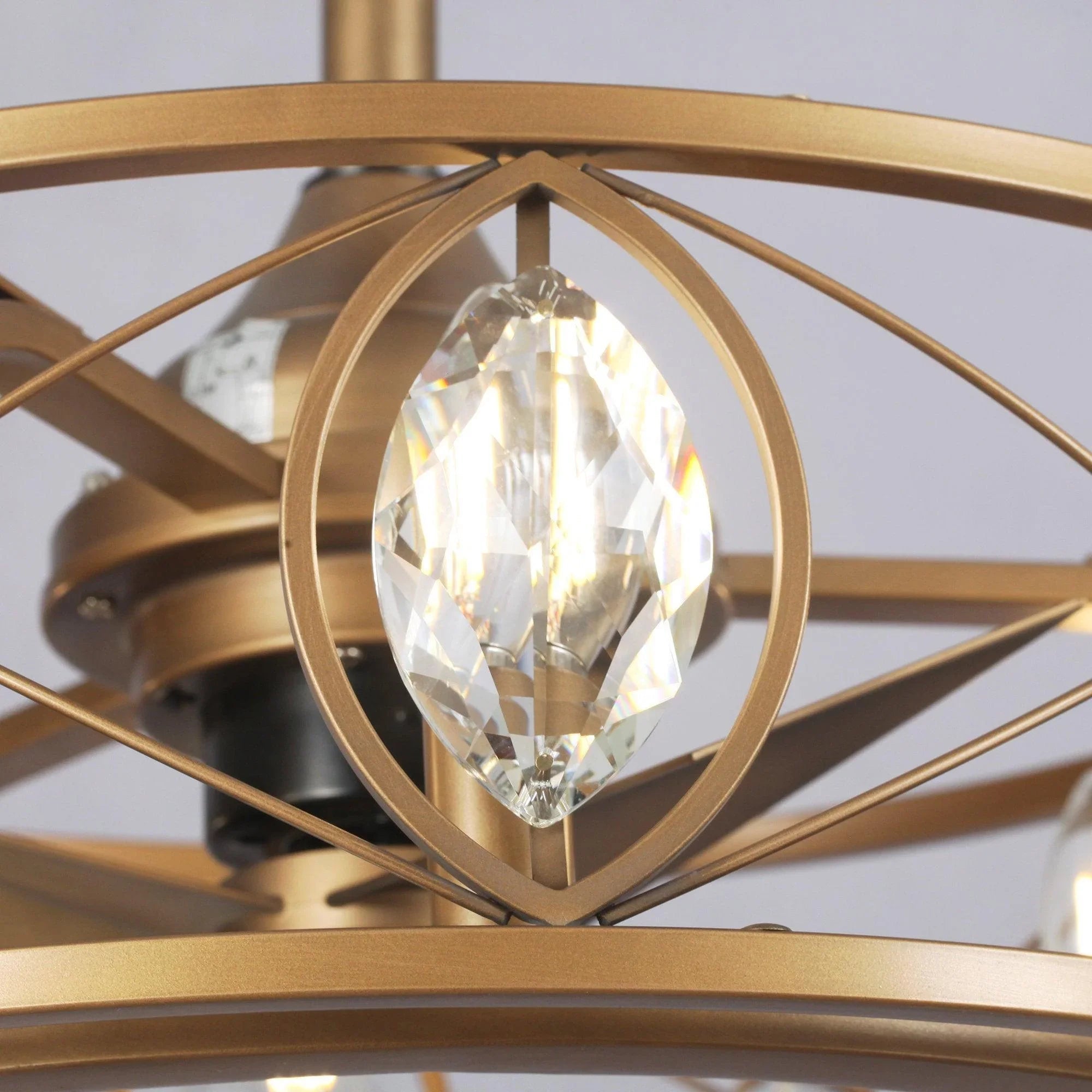 Gold ceiling fan chandelier close-up of faceted crystal teardrop in metal frame