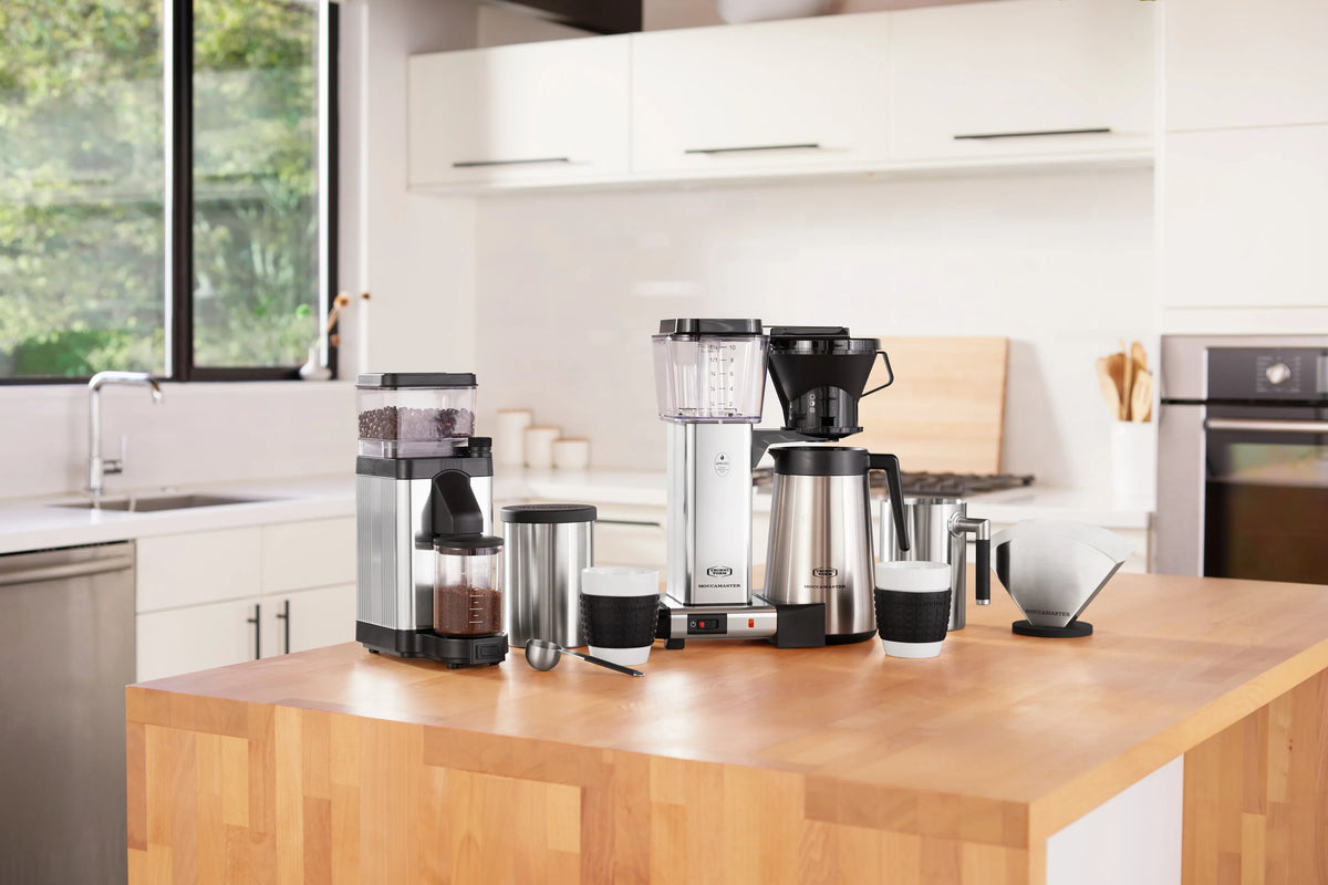 Polished silver burr grinder with transparent bean hopper and countertop stand