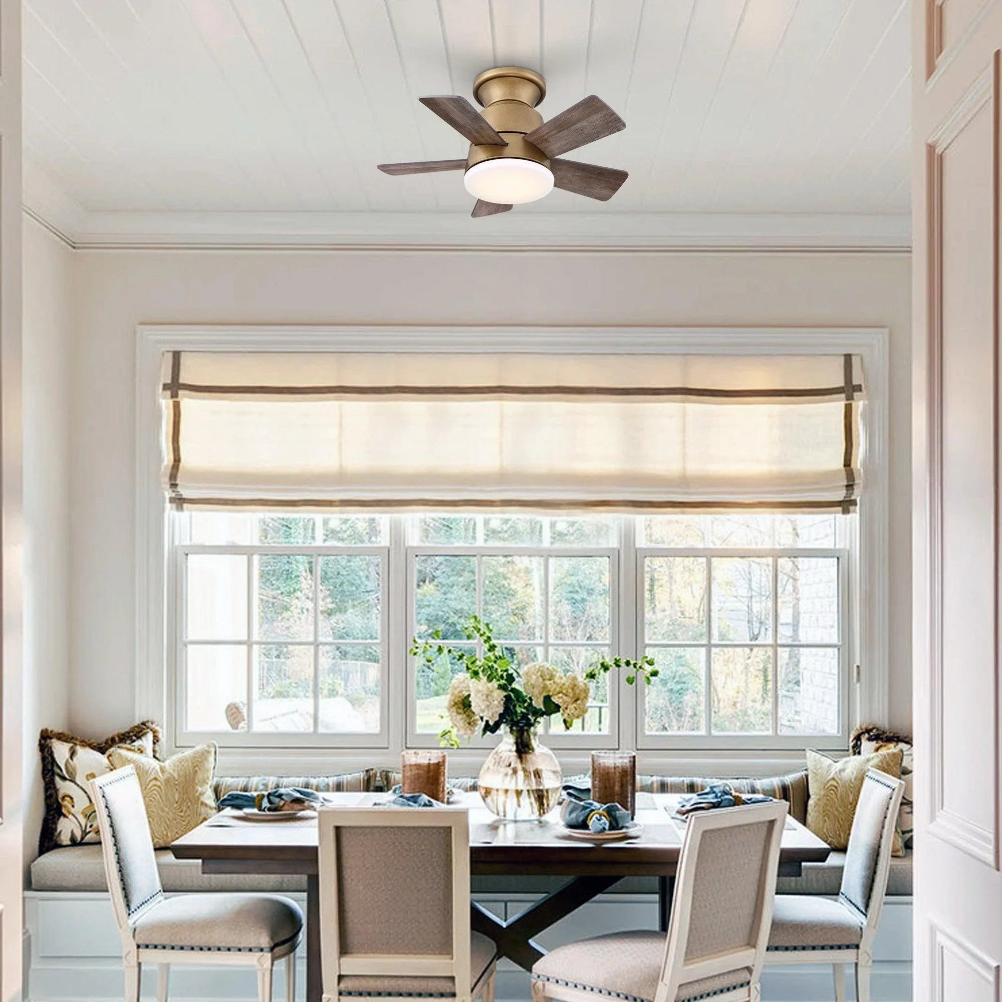 Flush mount ceiling fan with reversible blades and frosted light mounted to the ceiling