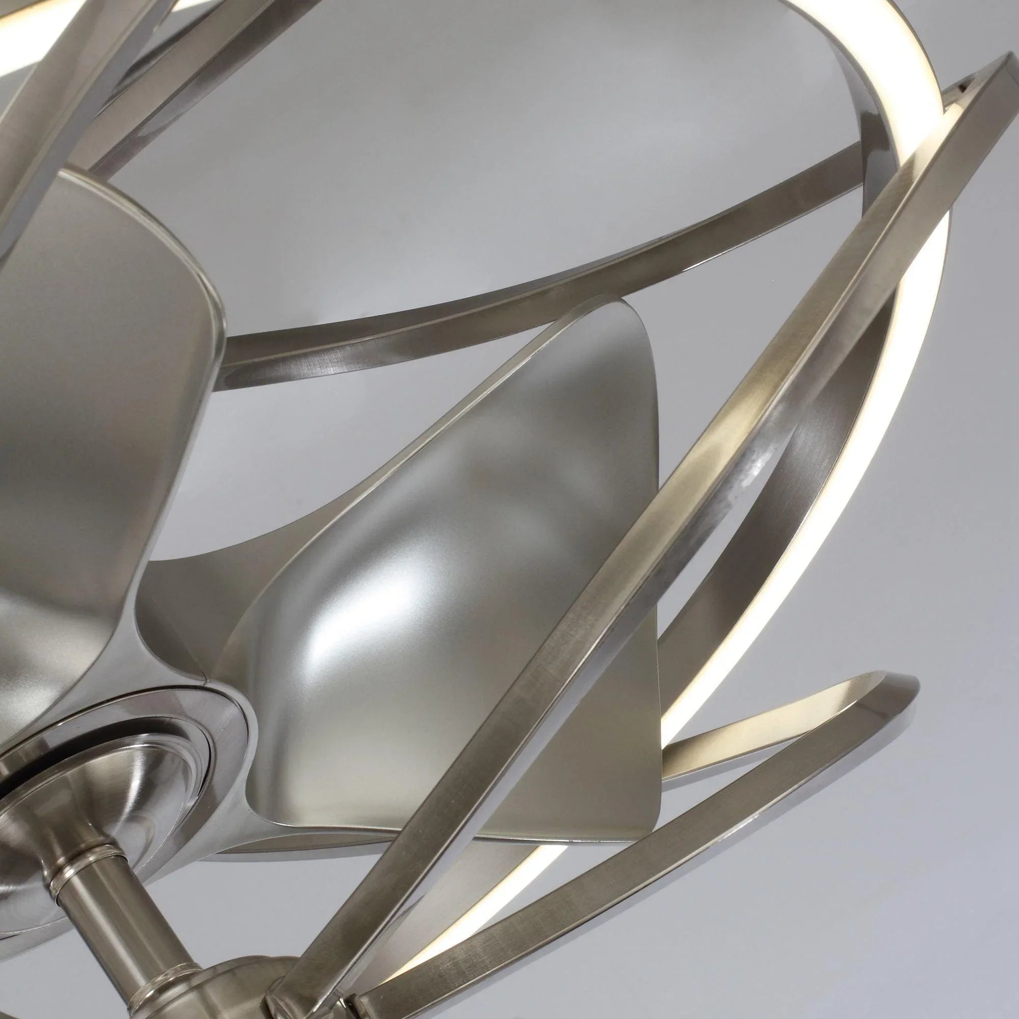 Close-up of brushed nickel ceiling fan blades with glowing light accents