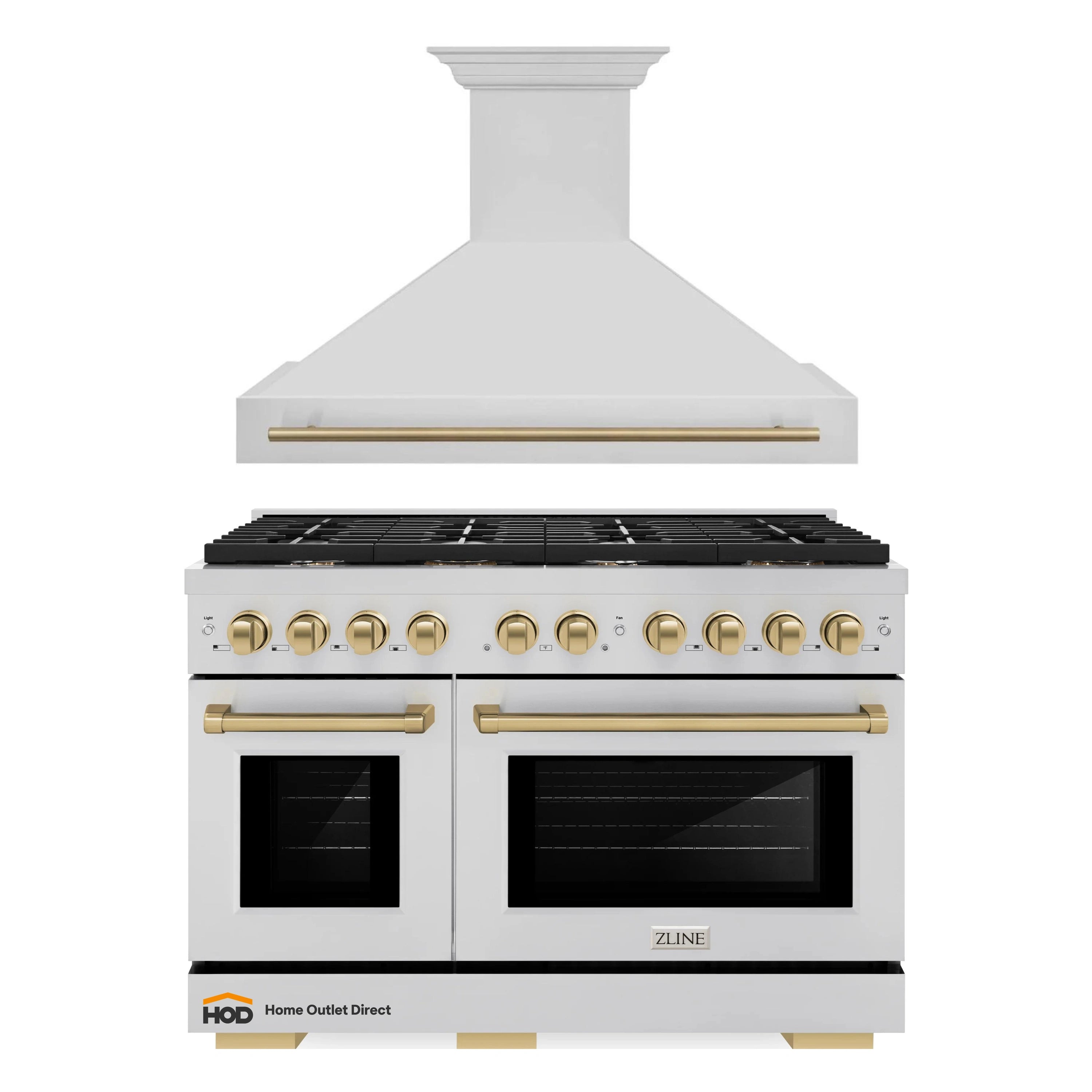 Stainless gas range with wall hood, black cooktop, and champagne bronze handles