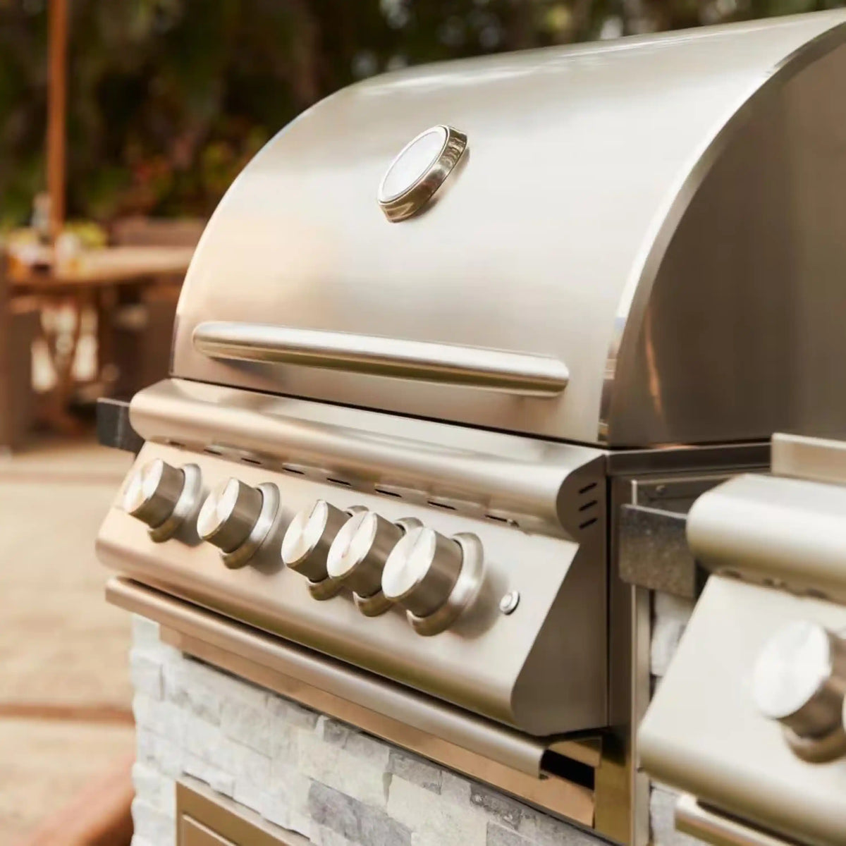 Stainless propane gas grill with lift-assist lid open and burner control knobs