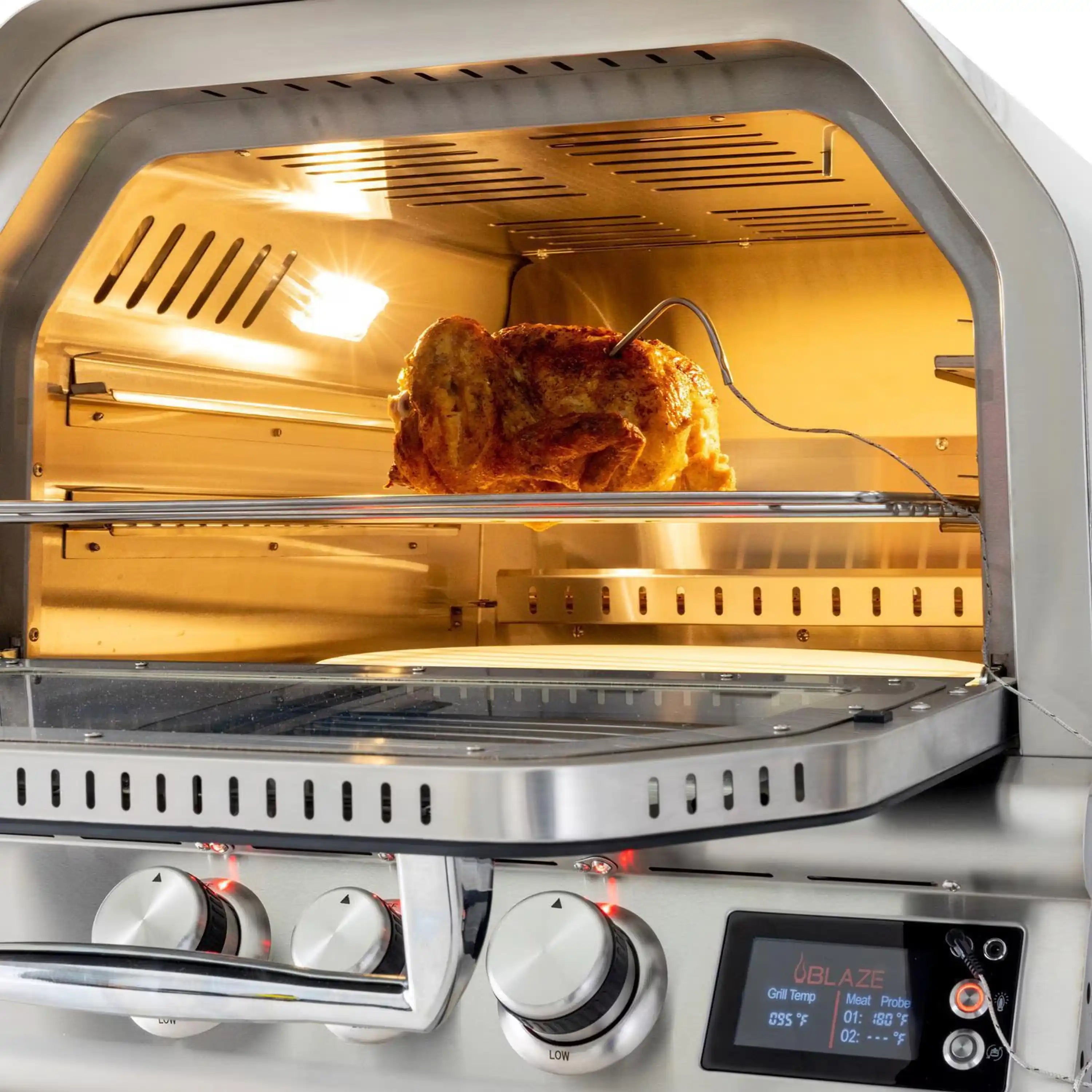 Blaze outdoor pizza oven with rotisserie roasting inside the heated chamber