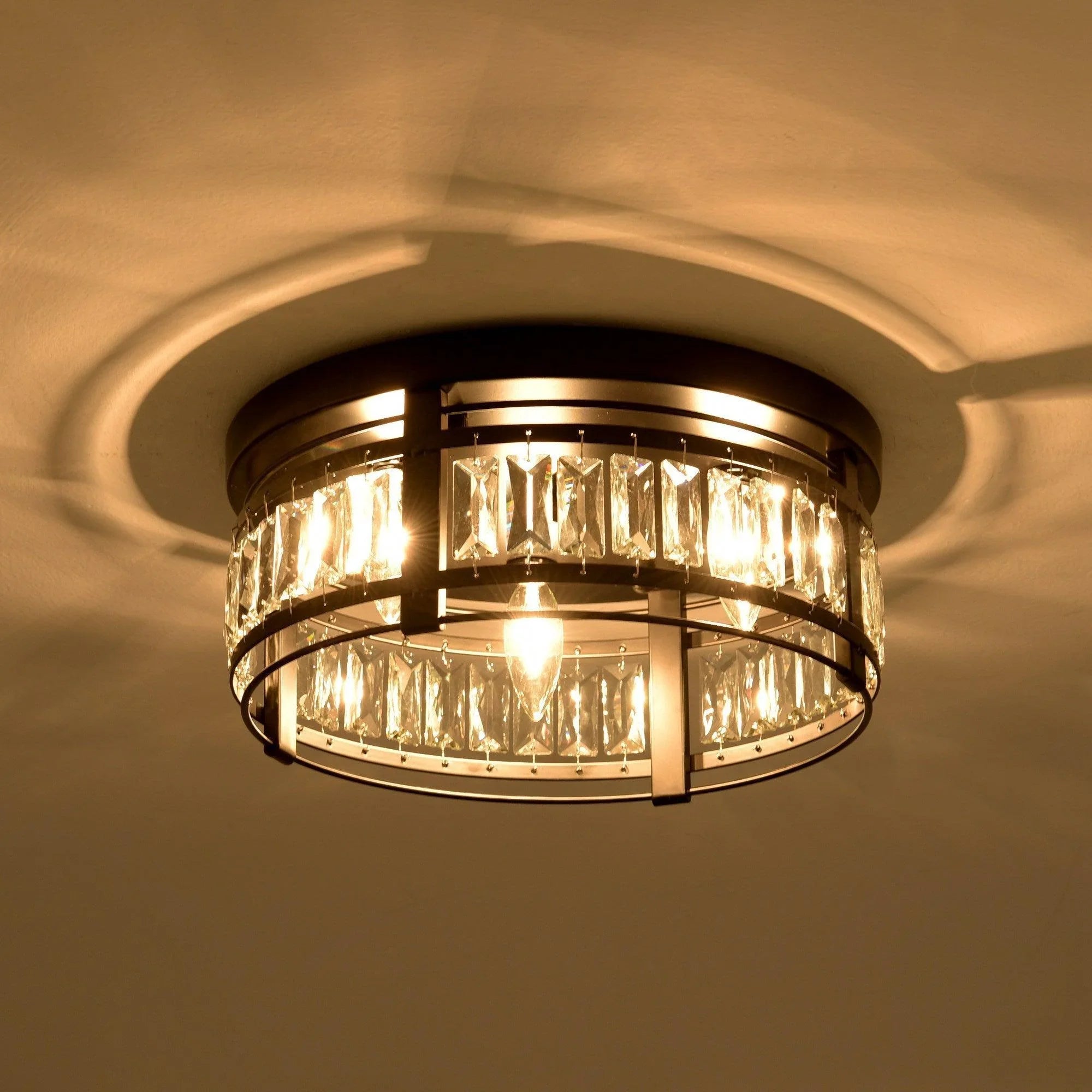 Lit black flush mount ceiling light with clear crystal prisms and three exposed bulbs