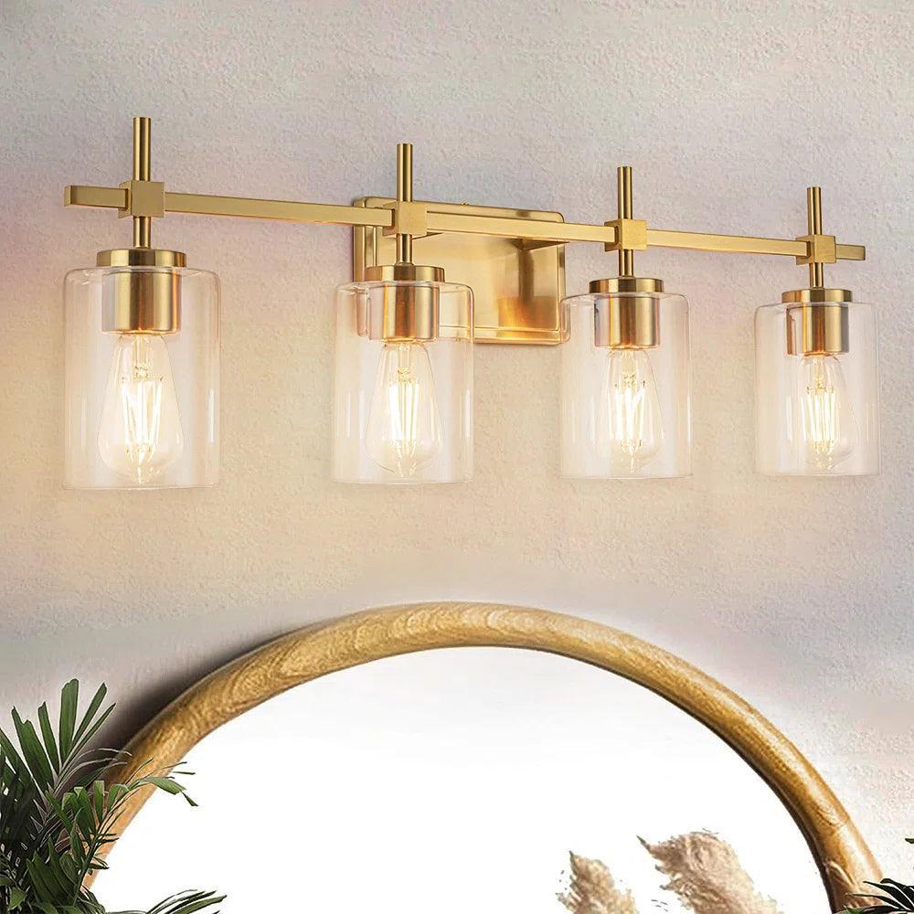 Golden 4-light bathroom vanity light with clear glass shades mounted above mirror