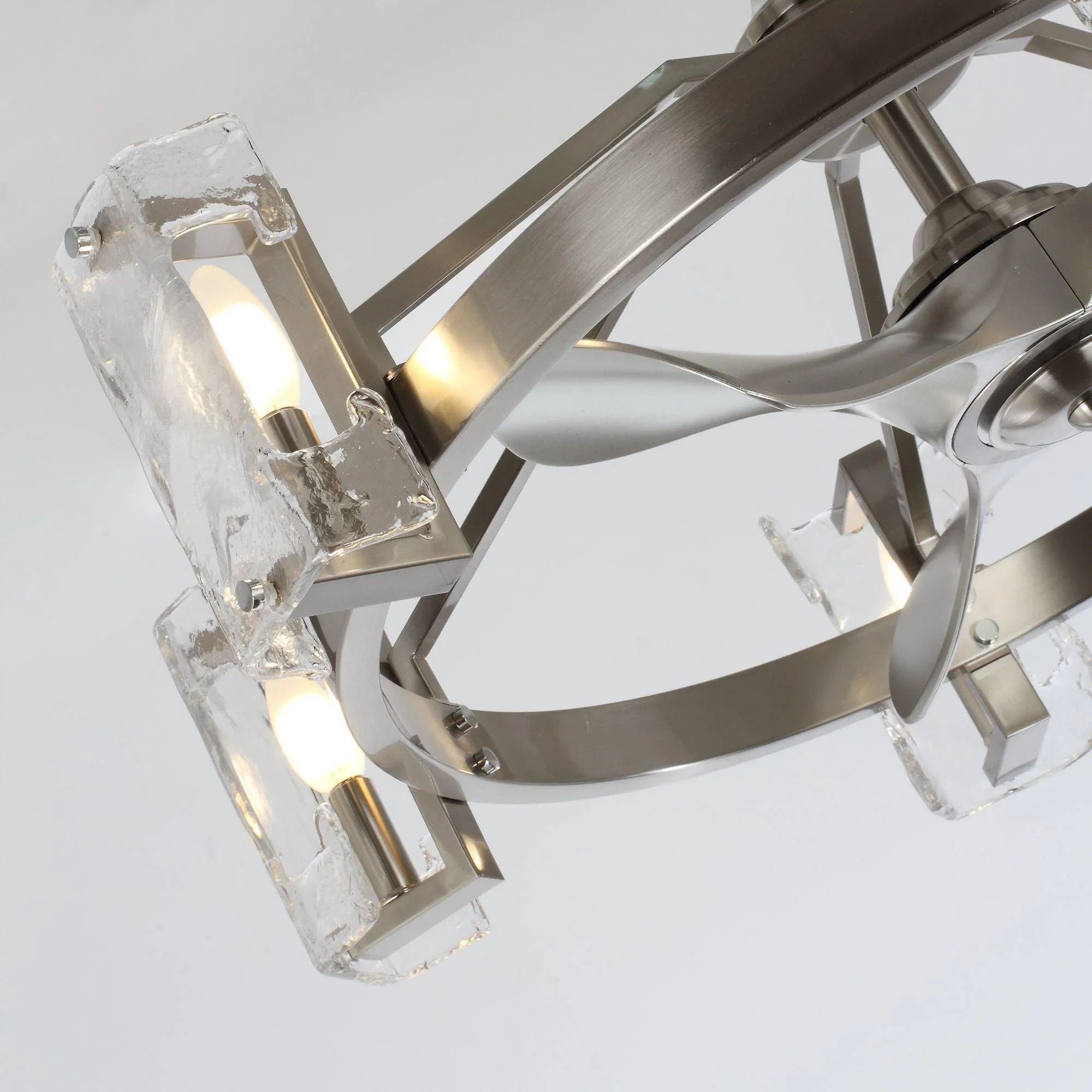 Brushed nickel ceiling fan close-up of frame arms and clear glass light fixture