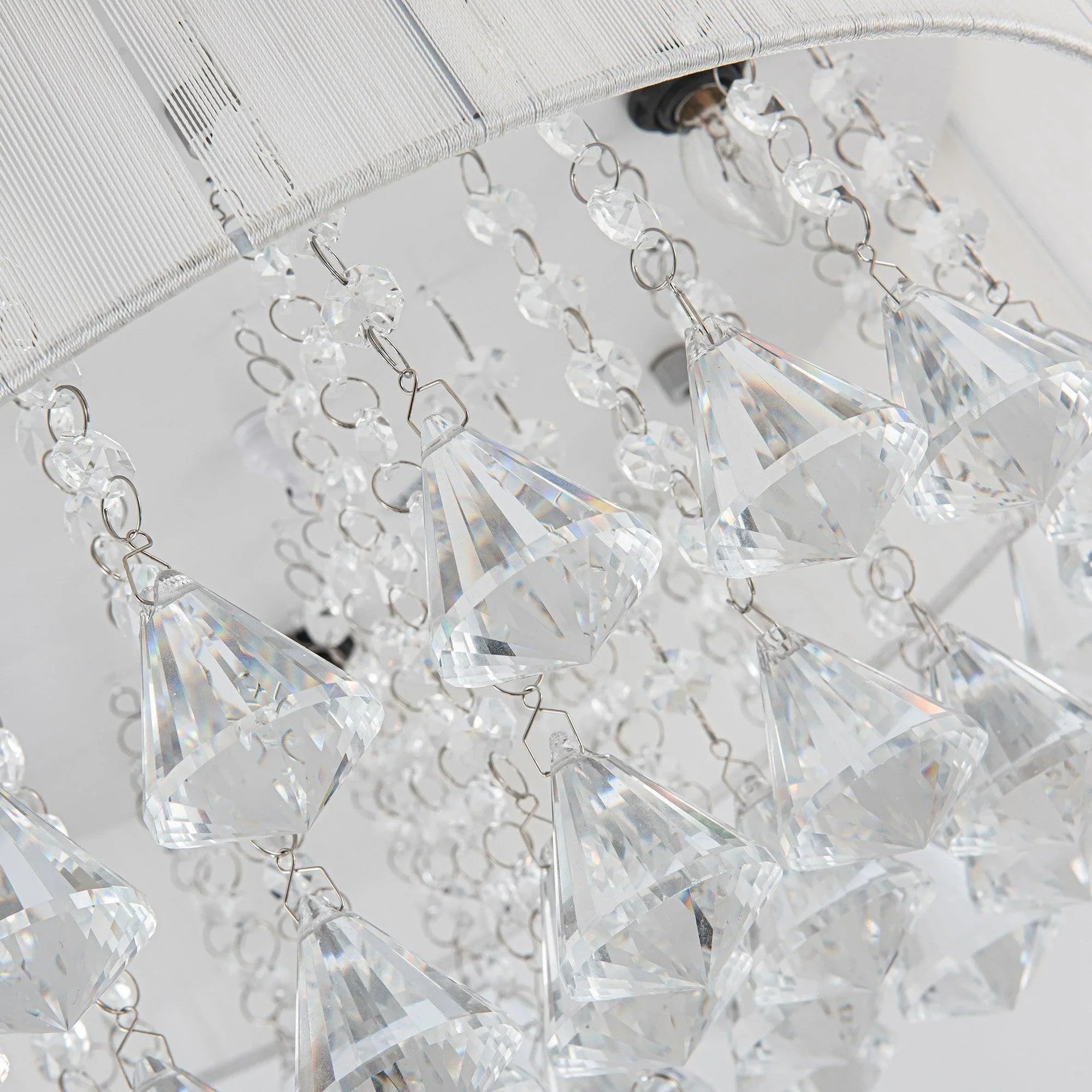Crystal ceiling fan light with clear teardrop prisms and metal links, close-up