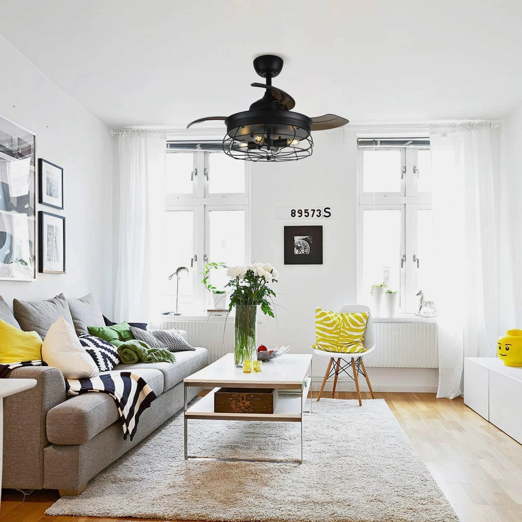 Black ceiling fan with cage light fixture and retractable blades in a living room