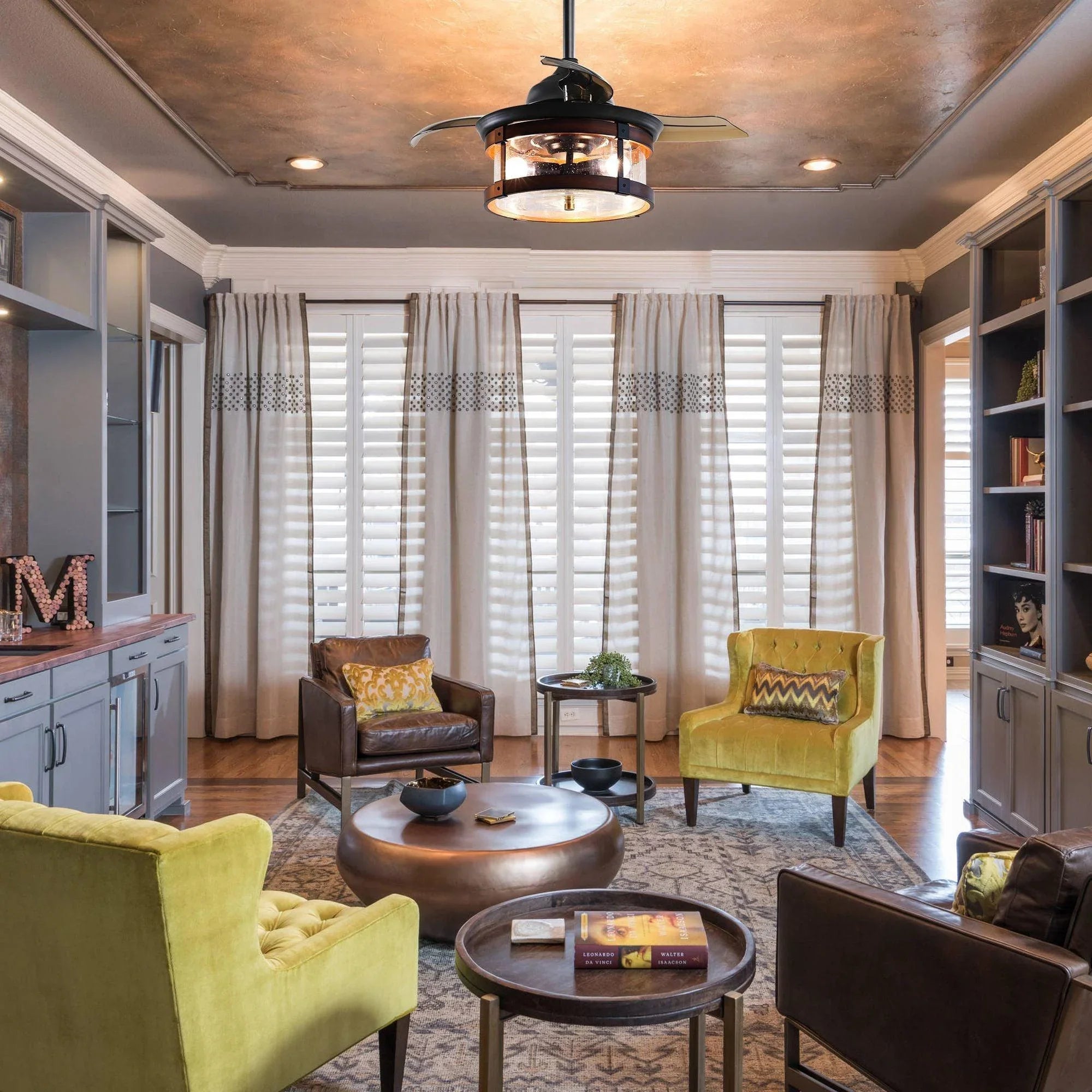 Ceiling fan with dark housing, wood-toned accents, and glass light panels.
