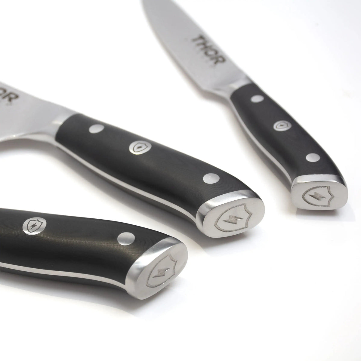 Damascus knife handles close-up, black grips with logo rivets and silver blades