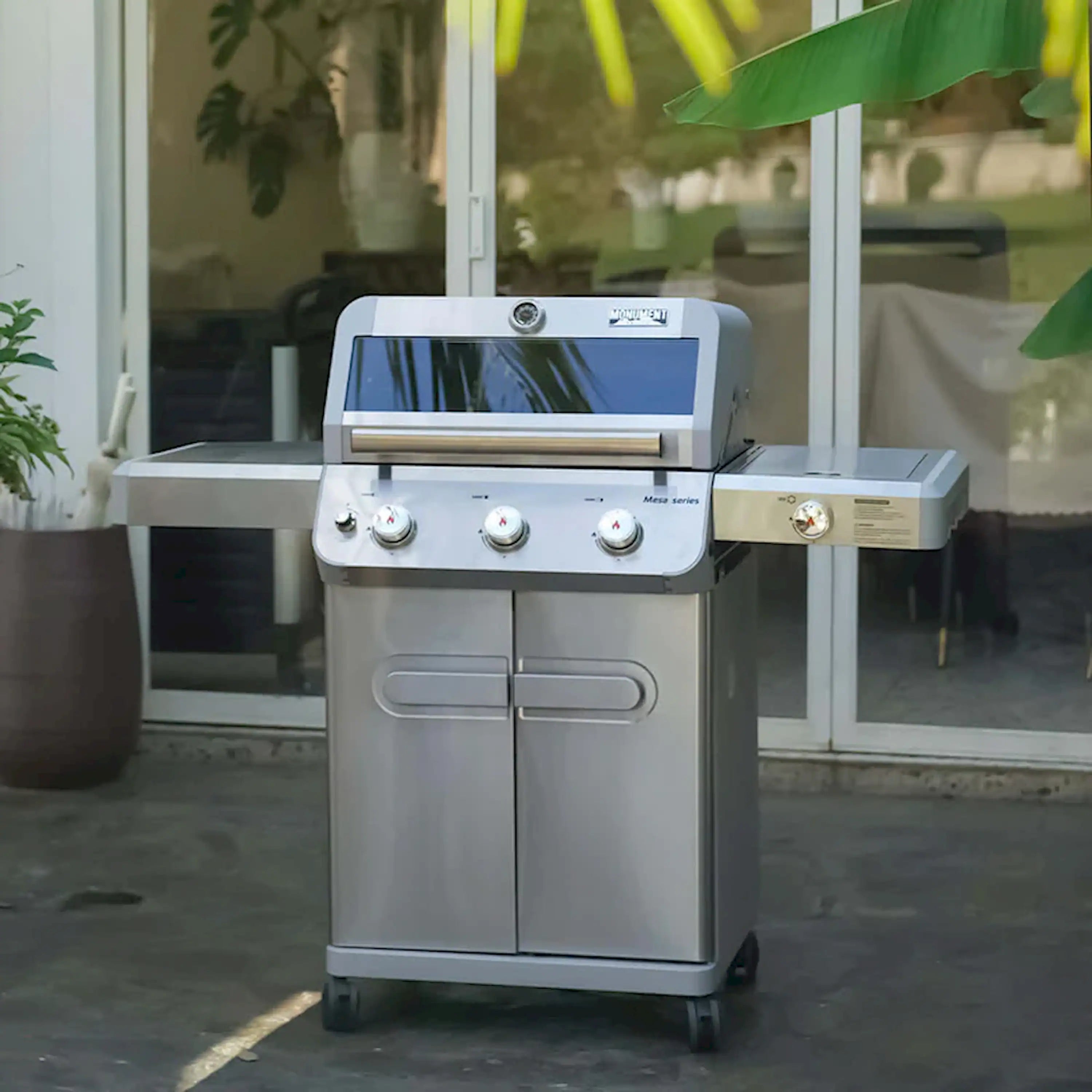 Stainless steel propane grill on wheels with three burners and front knobs