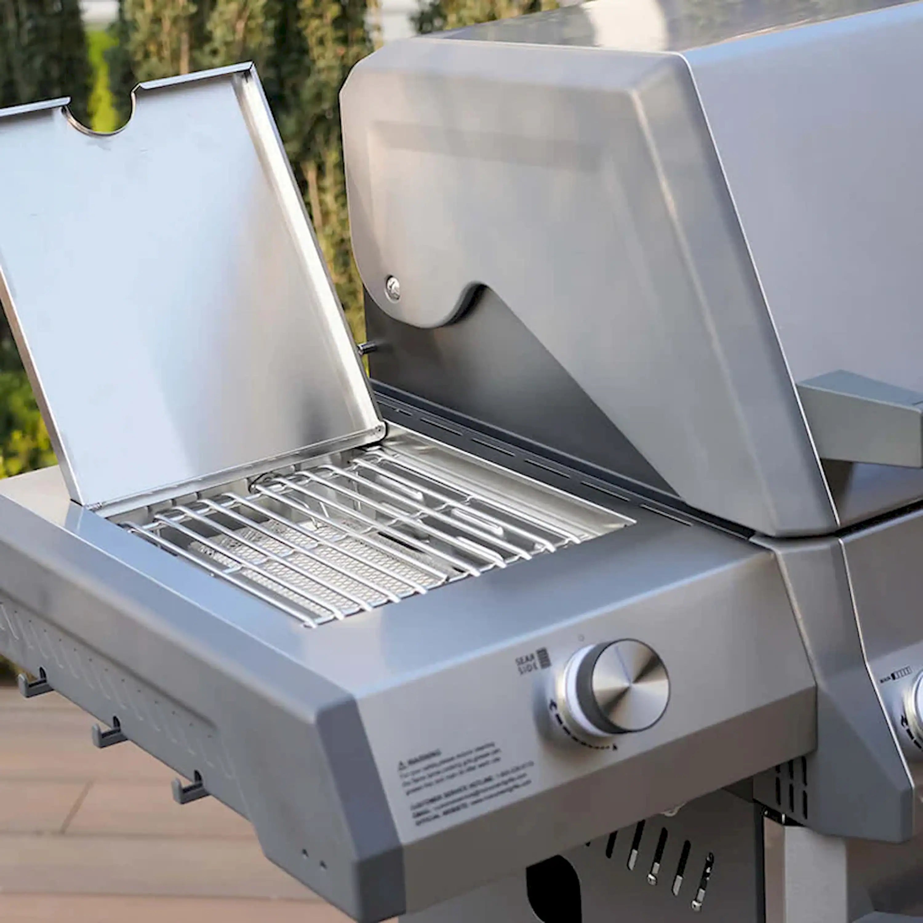 Open lid stainless gas grill with cooking grate and front knob controls