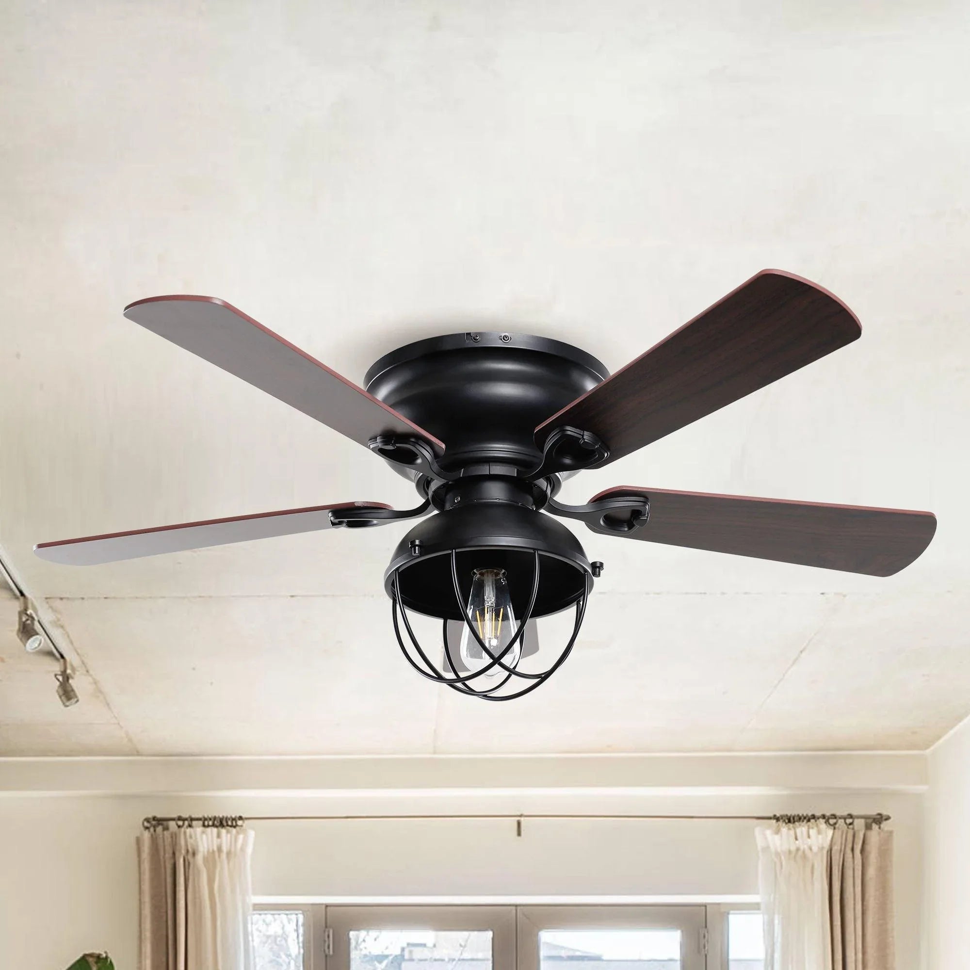 Black flush-mount ceiling fan with reversible dark wood blades and integrated light