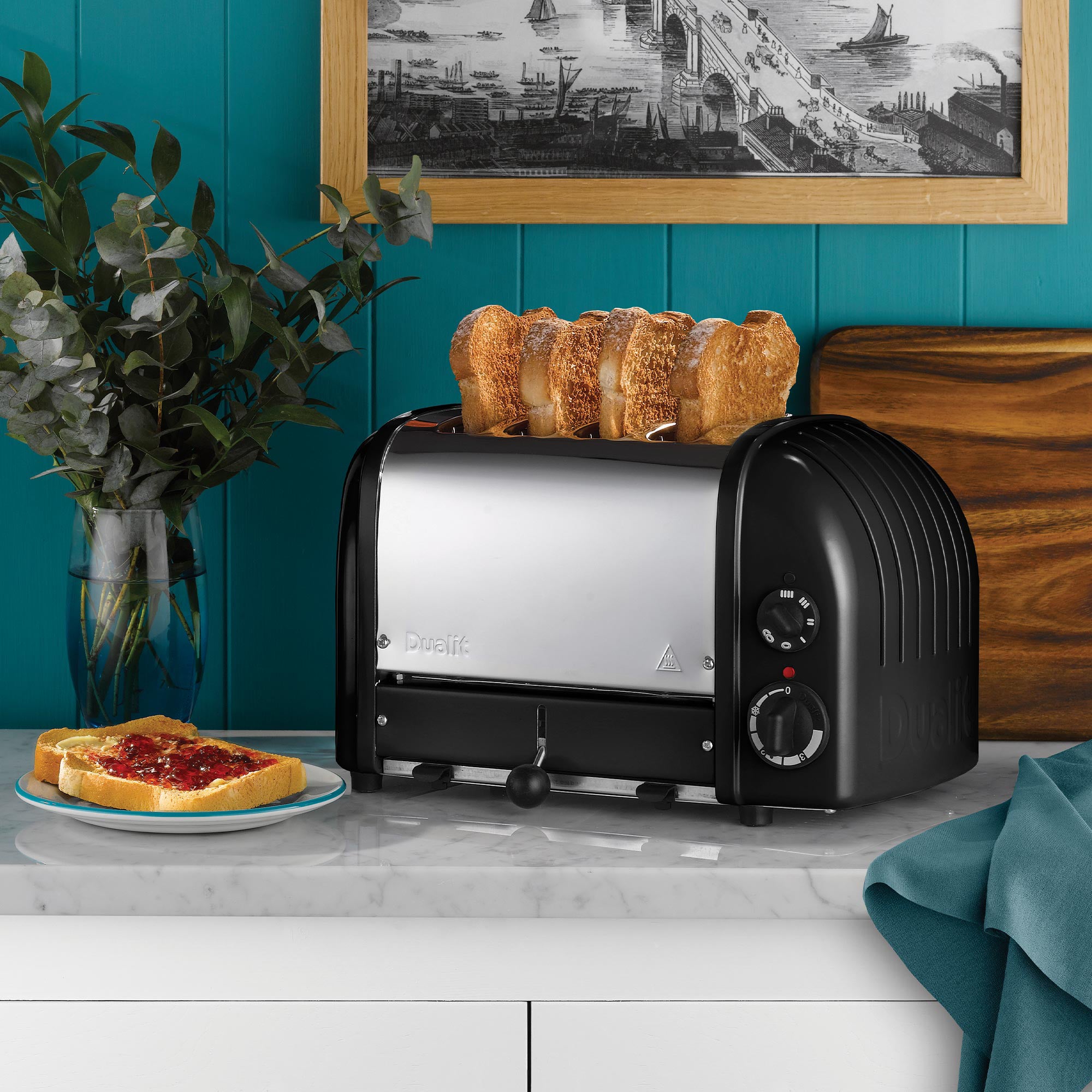 Dualit 4-slice NewGen toaster in matte black with sliced bread on top rack