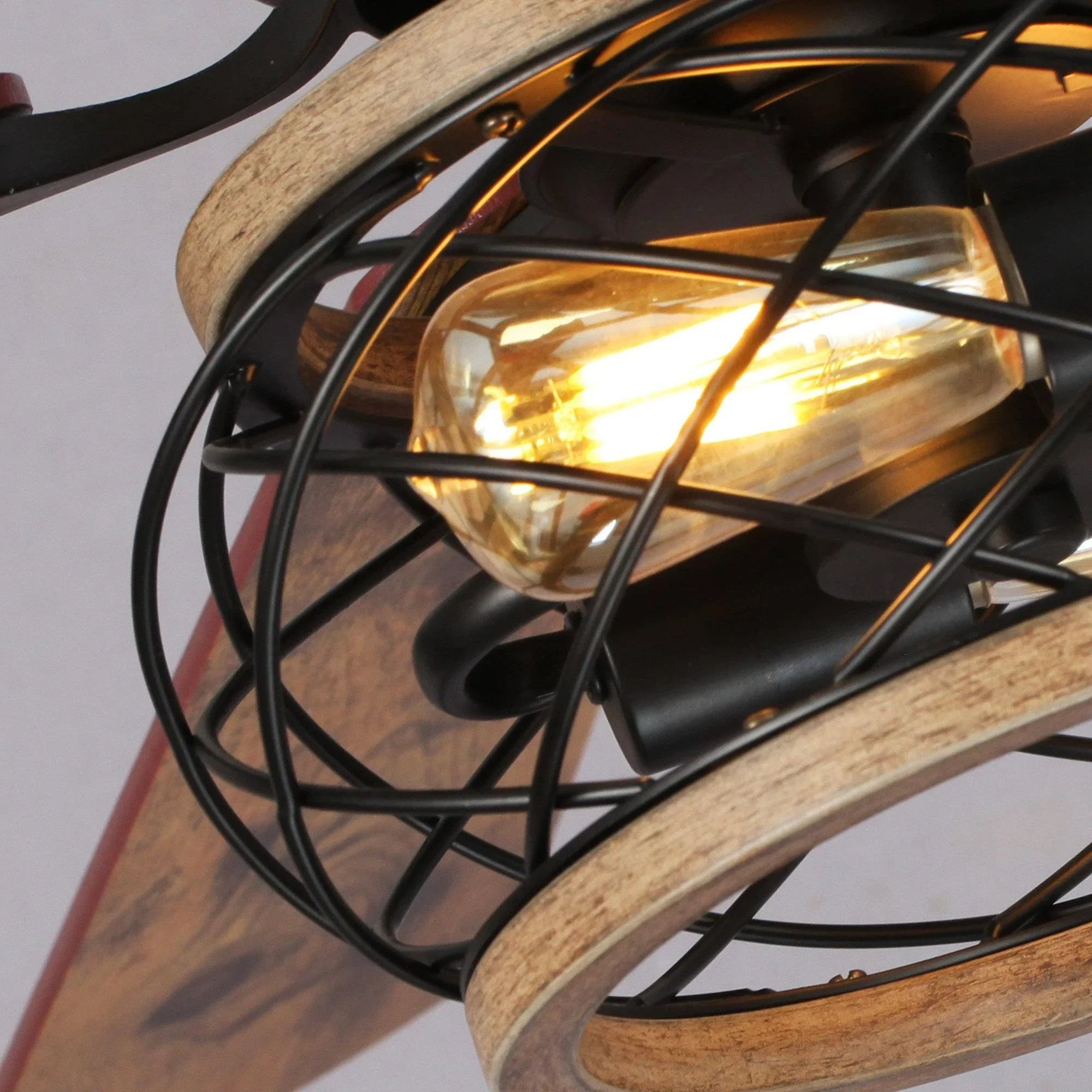 Black flush-mount ceiling fan with amber-glass light and black metal cage guard