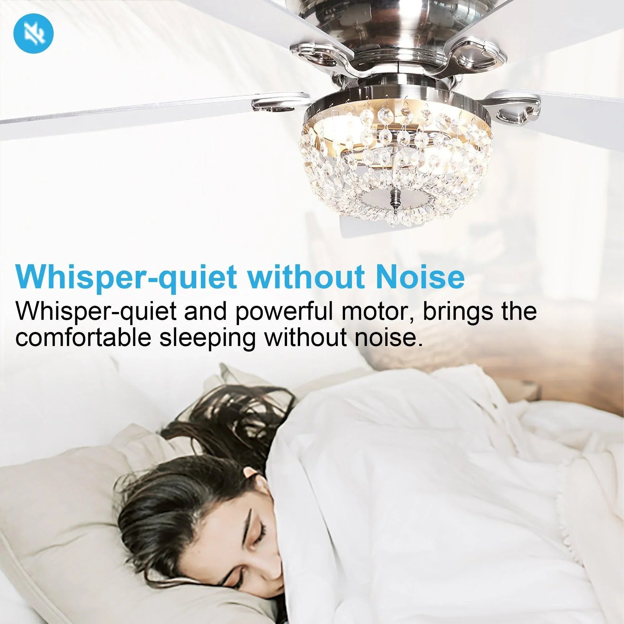 Ceiling fan with crystal light fixture and white blades above a bedroom bed