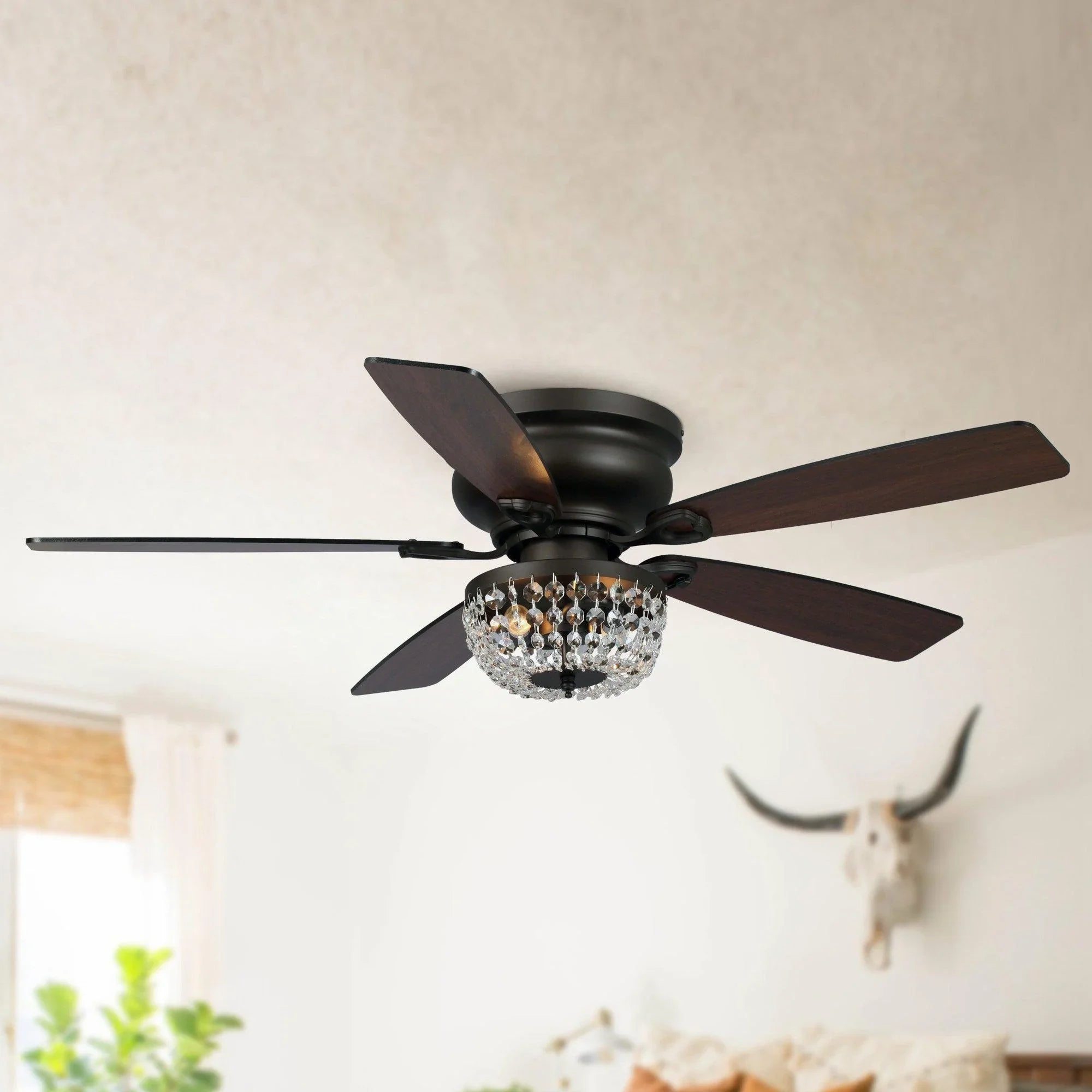 Flush mount ceiling fan with crystal light and dark wood-style blades on ceiling