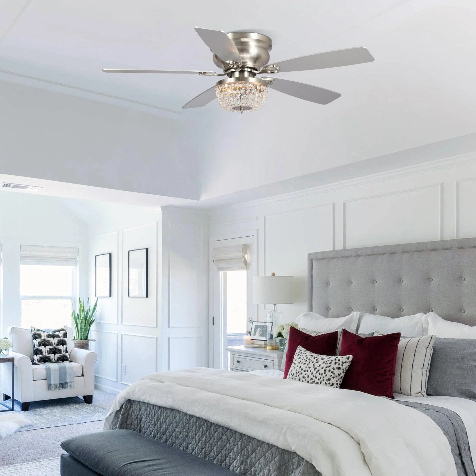 Brushed nickel flush-mount ceiling fan with crystal light above modern bedroom