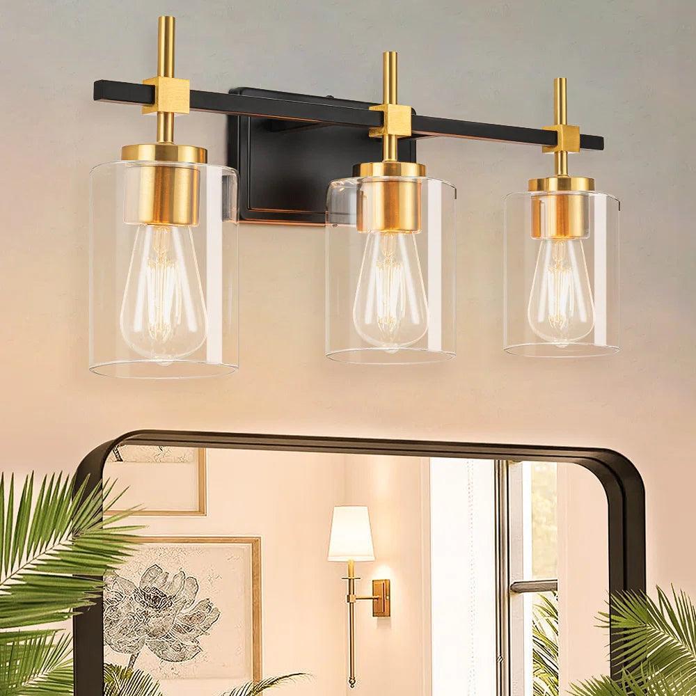 3-light bathroom vanity light with clear glass shades, black metal bar and gold mounts