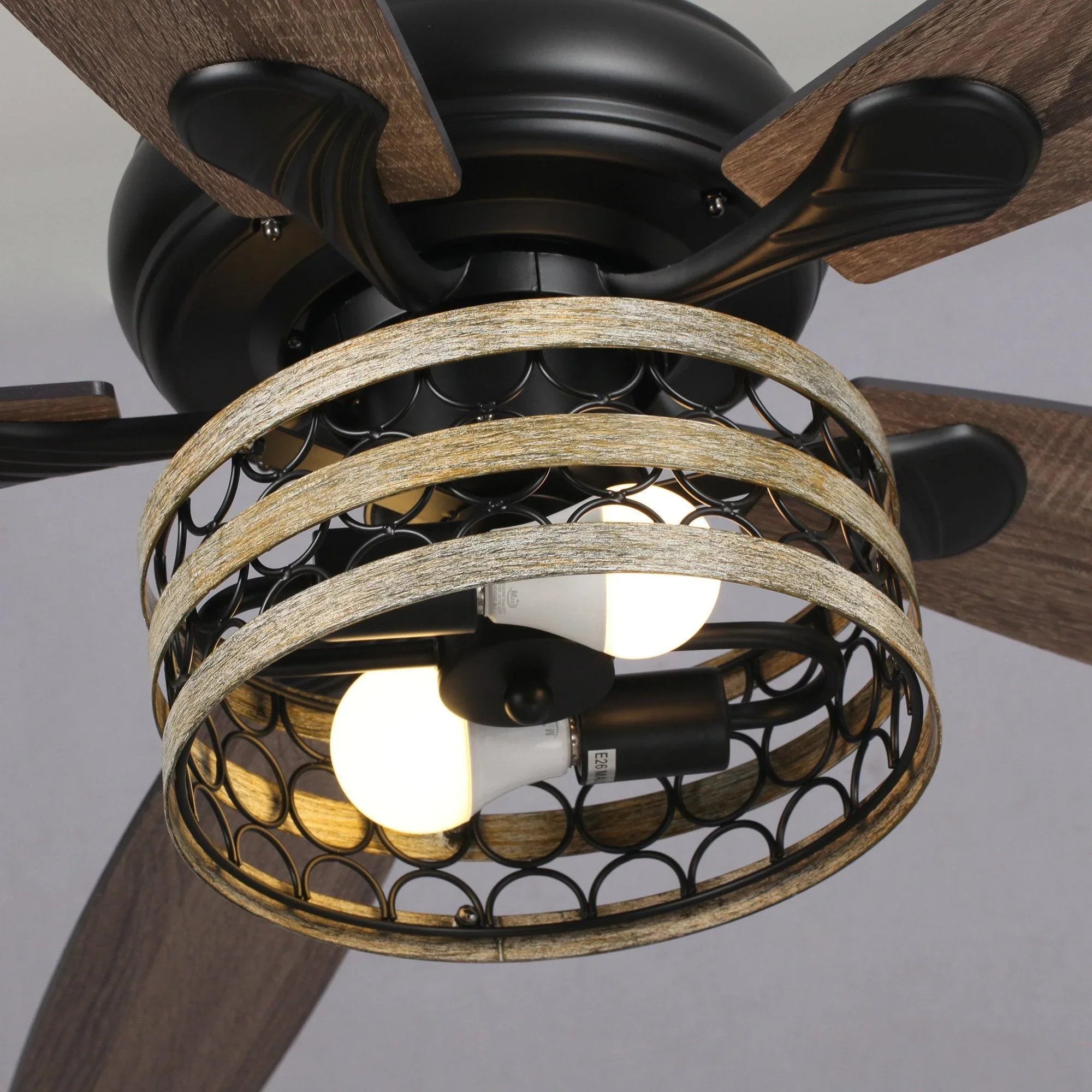Black ceiling fan motor with dark wood blades and decorative light cage