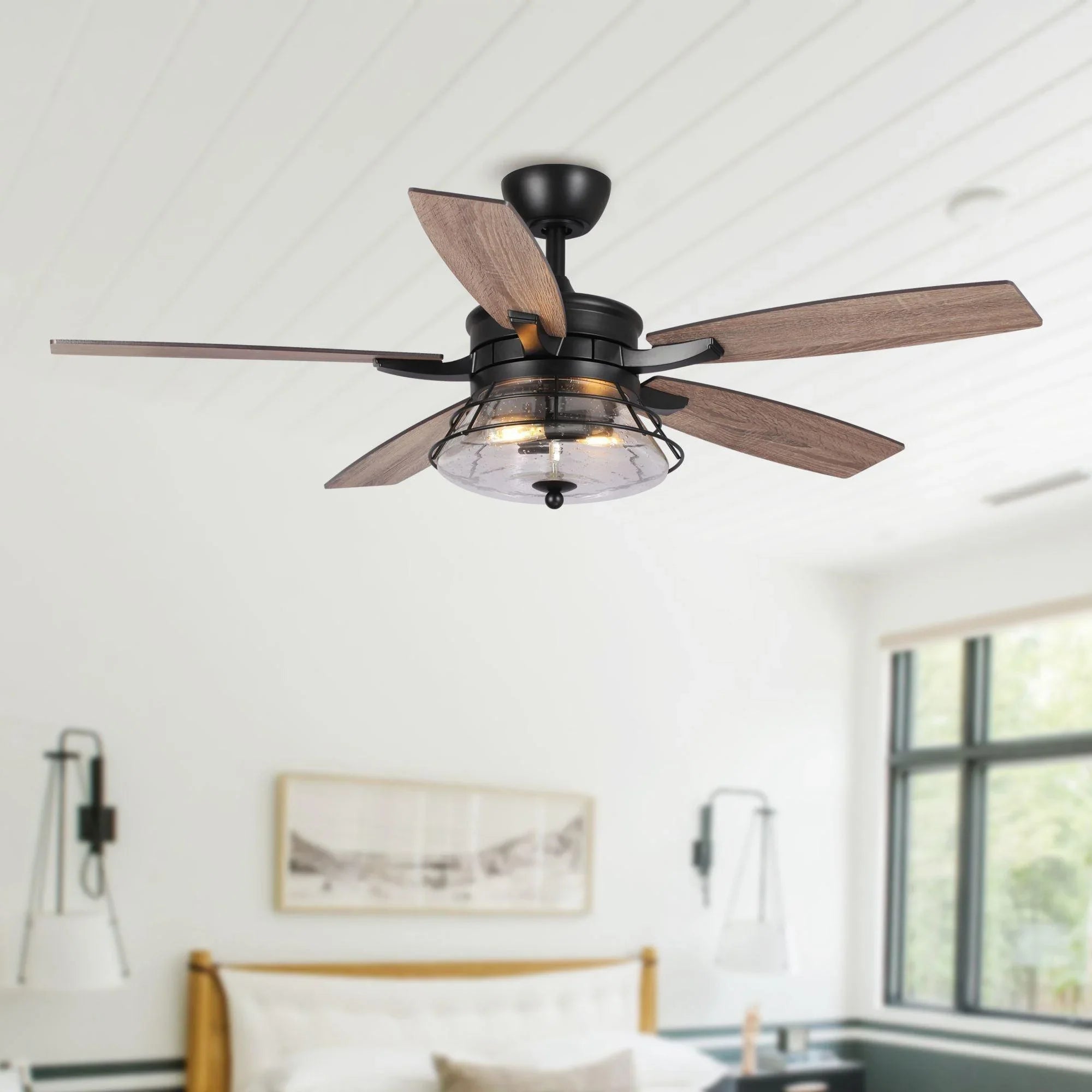 Ceiling fan with black housing, wood blades, and clear glass light globe