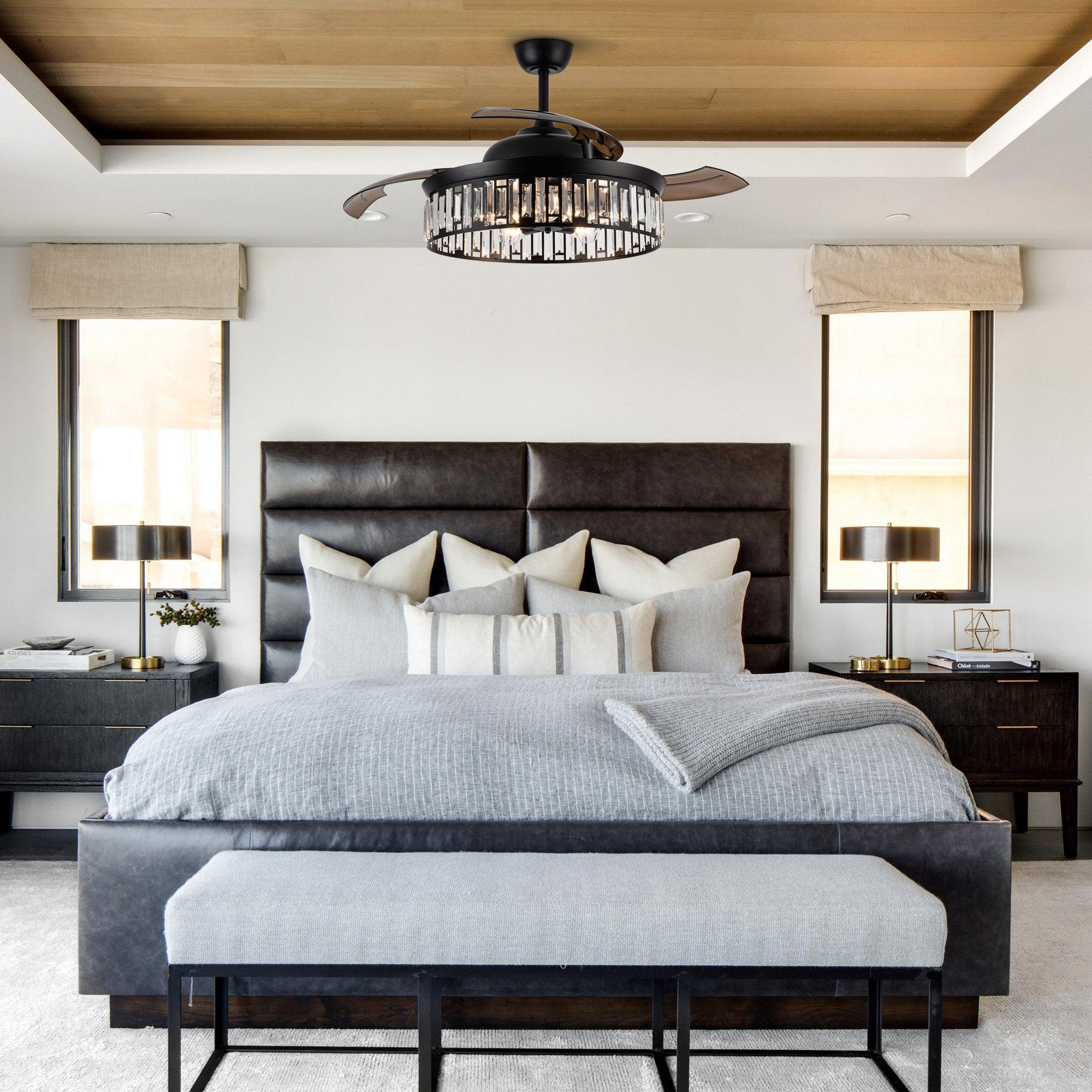 Black smart ceiling fan with light kit above a bed, clear-glass bulbs visible