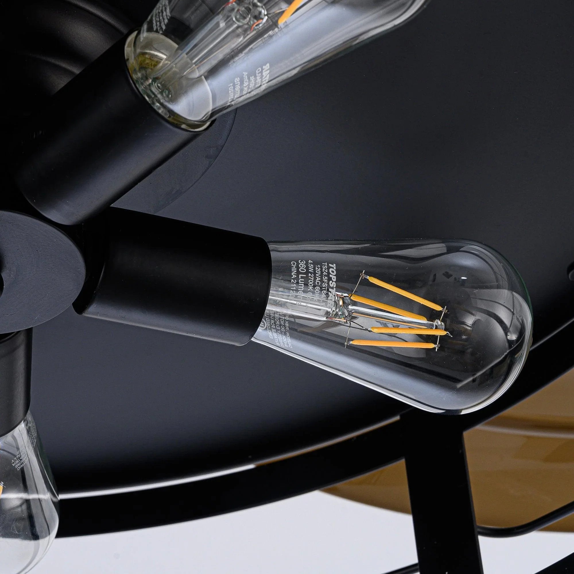 Black ceiling fan light fixture with clear glass bulb housing and visible filament wires