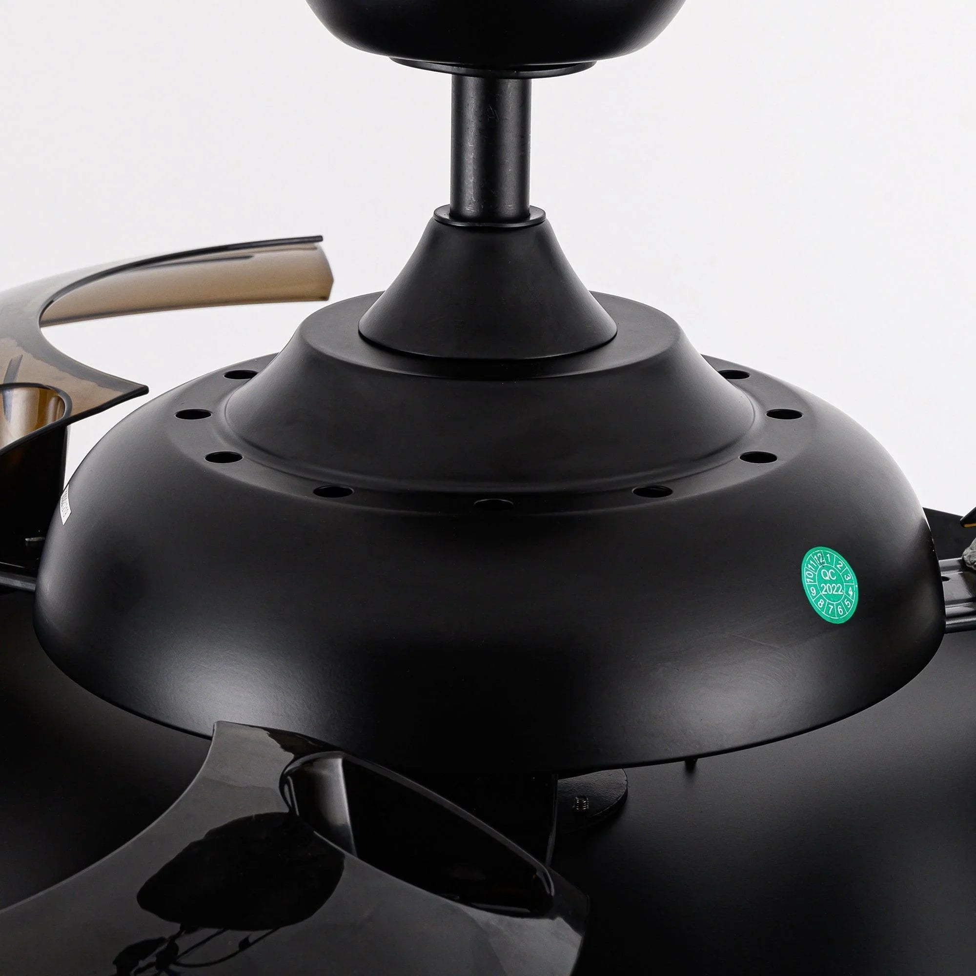 Black ceiling fan motor base with circular mounting holes and central downrod