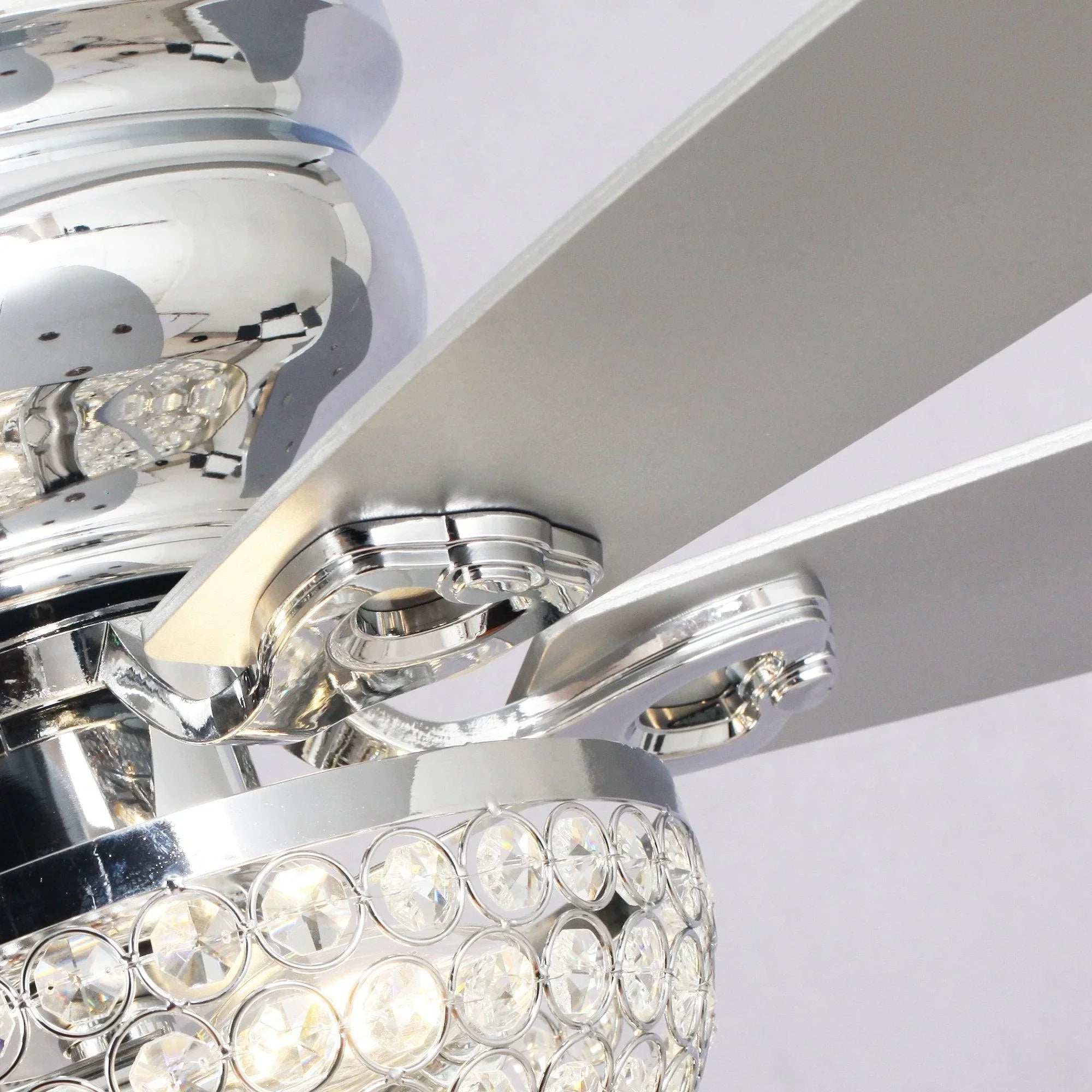 Chrome ceiling fan housing with crystal light cluster and angled blade detail