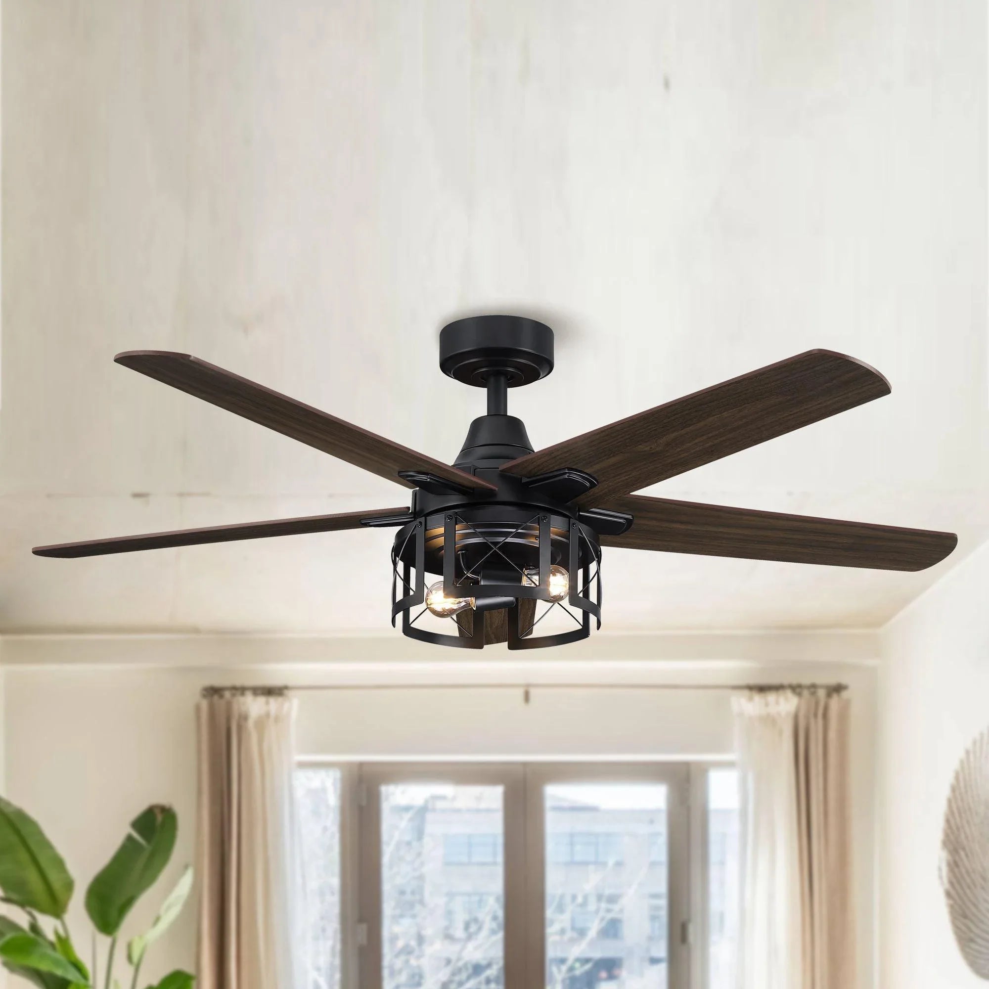 Black ceiling fan with dark wood blades and lit lantern-style light