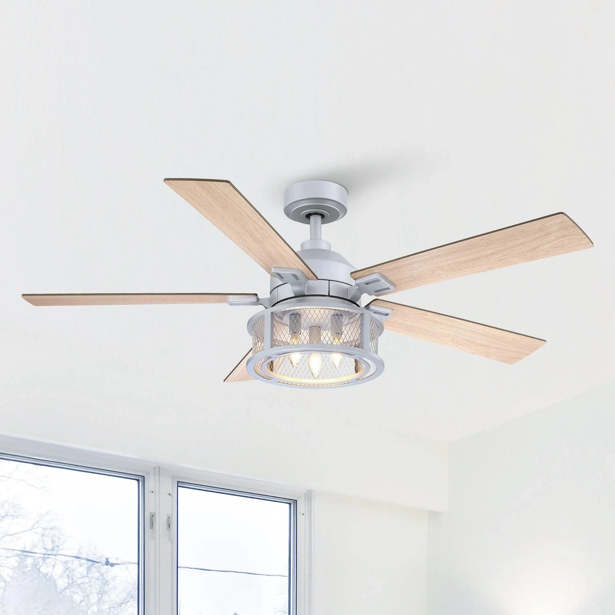 Silver ceiling fan with light kit and five wood blades mounted on ceiling