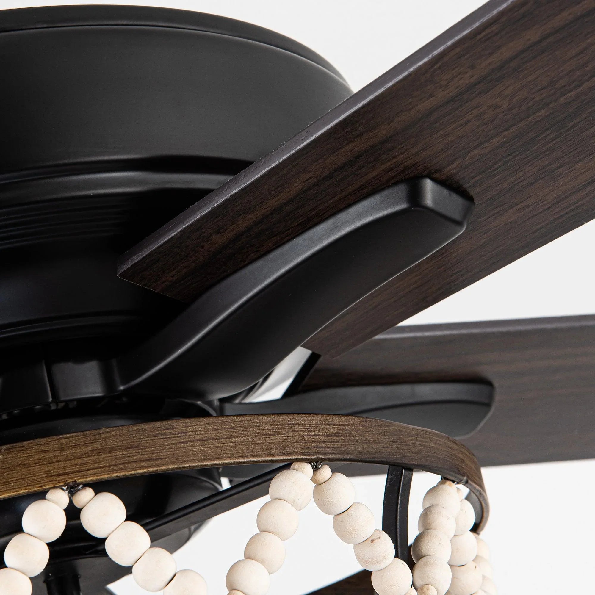 Ceiling fan blade detail with black housing and bead-style light accents