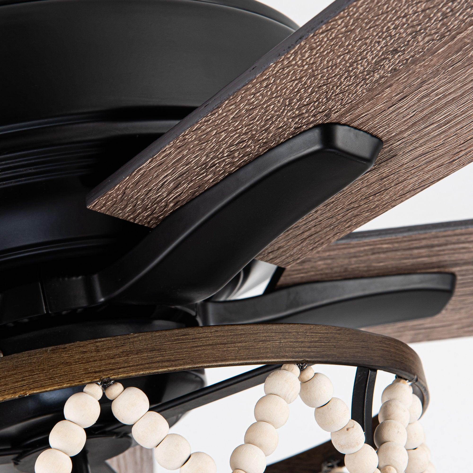 Ceiling fan blade and black motor arm close-up with white bead light accents