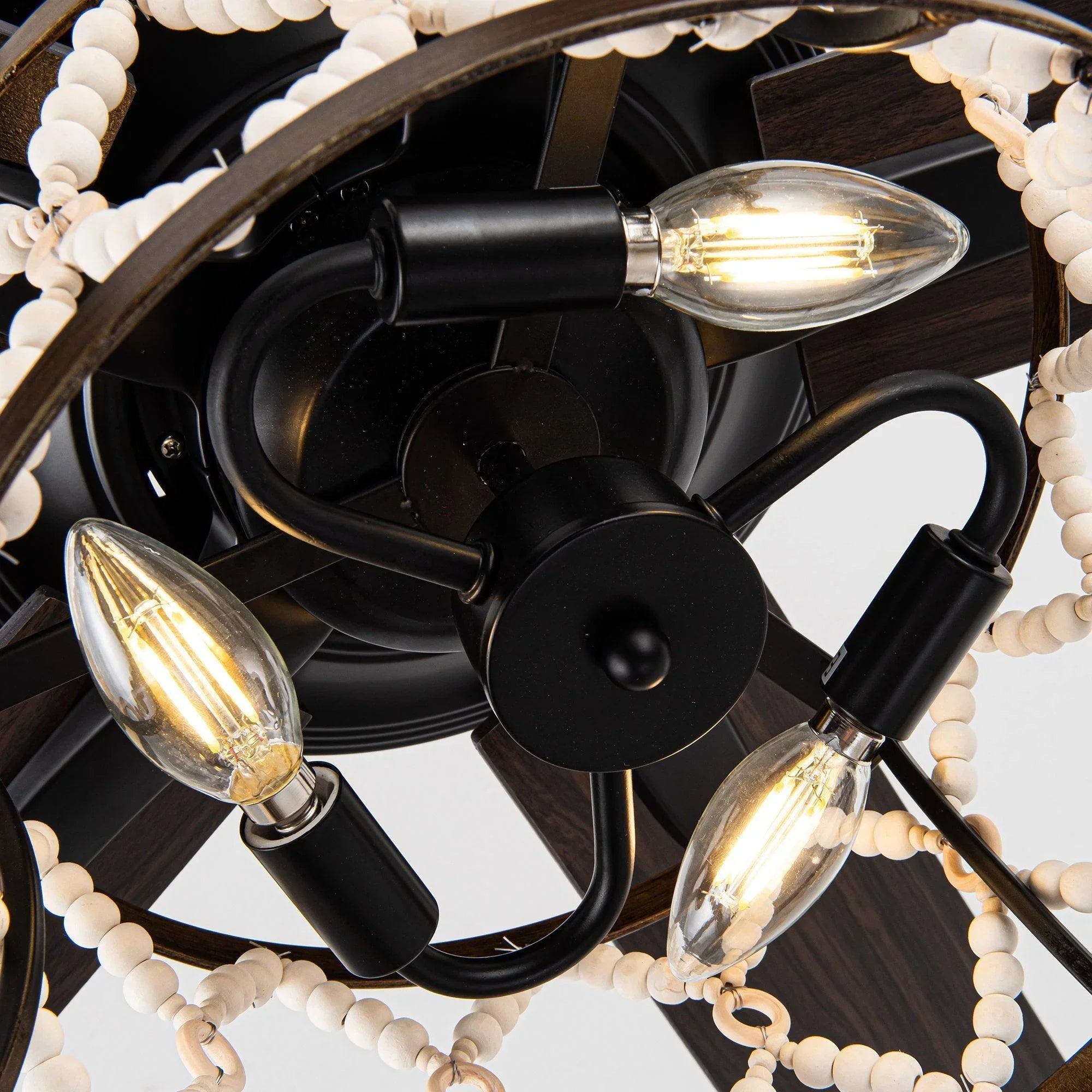 Black motor housing with four clear glass candelabra bulbs around cage.