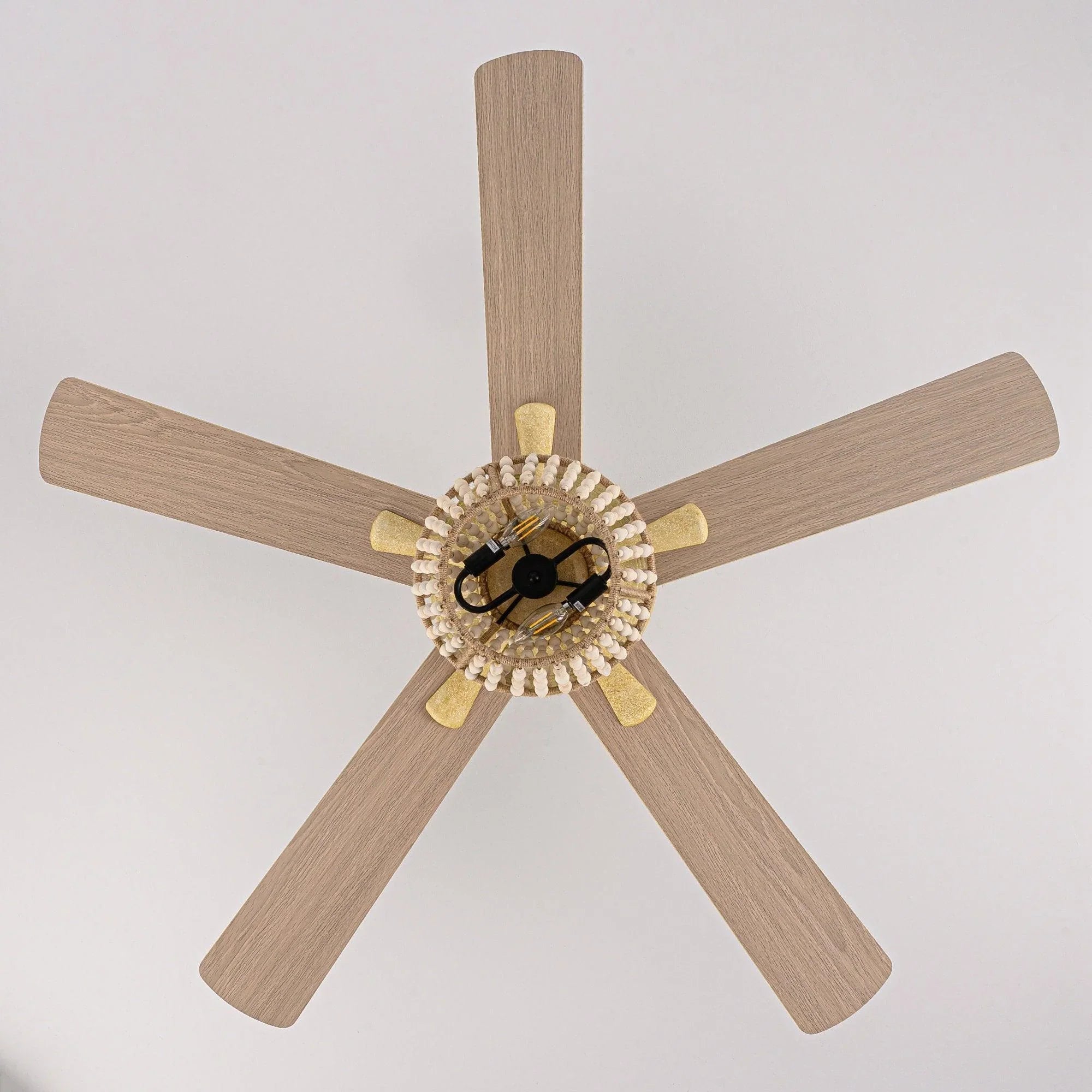 Golden ceiling fan head with 5 wood blades and center light socket detail